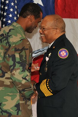 OFFUTT AIR FORCE BASE, Neb. - Master Sgt. Dietrich Kirk, a former Offutt firefighter now stationed at Barksdale AFB, La., presents a model B-52 aircraft to his former mentor Fire Chief Robin Gullie, 55th Civil Engineer Squadron, during his retirement ceremony Dec. 12, 2008.  (Photo By: Charles Haymond).