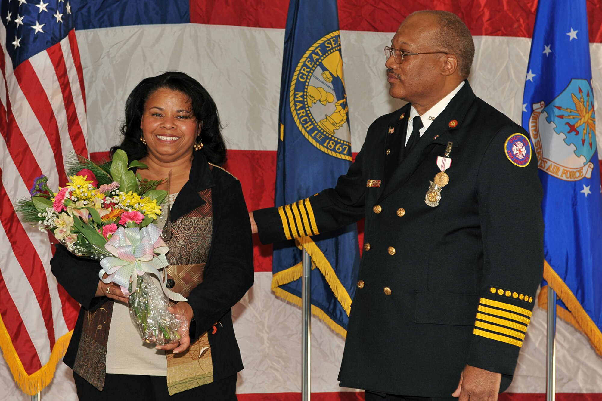 OFFUTT AIR FORCE BASE, Neb. - Barbara Gullie receives flowers from her husband Chief Robin Gullie, 55th Civil Engineer Squadron, during his retirement ceremony Dec. 12. After 38 years of service to the Air Force, Chief Gullie thanked his wife for her many years of sacrifice and dedication. (Photo By: Charles Haymond).  
