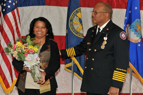 OFFUTT AIR FORCE BASE, Neb. - Barbara Gullie receives flowers from her husband Chief Robin Gullie, 55th Civil Engineer Squadron, during his retirement ceremony Dec. 12. After 38 years of service to the Air Force, Chief Gullie thanked his wife for her many years of sacrifice and dedication. (Photo By: Charles Haymond).  