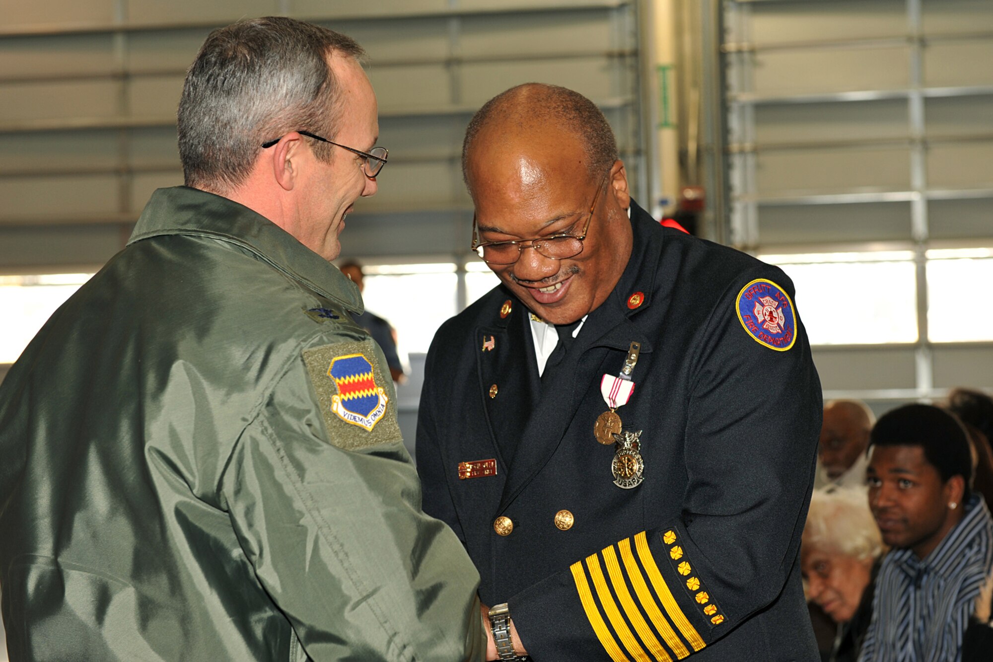 OFFUTT AIR FORCE BASE, Neb. - Col. Robert Maness, 55th Wing vice commander, coins Chief Robin Gullie, 55th Civil Engineer Squadron, during his retirement ceremony Dec. 12. Colonel Maness is one of more than 200 people who came out to honor Chief Gullie and help celebrate his many accomplishments during his 38 years of service to the U.S. Air Force.  (Photo By: Charles Haymond). 