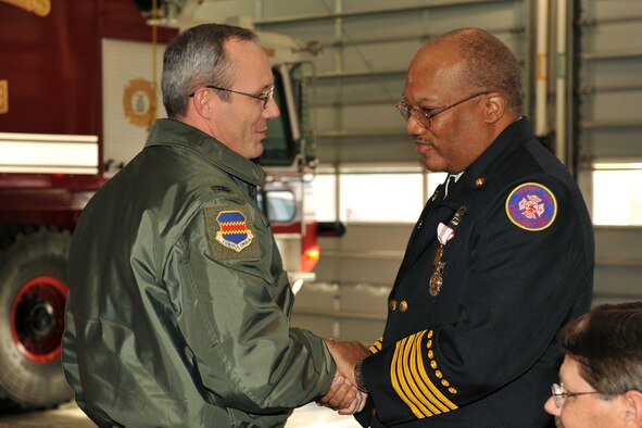 OFFUTT AIR FORCE BASE, Neb. - Col. Robert Maness, 55th Wing vice commander, coins Chief Robin Gullie, 55th Civil Engineer Squadron, during his retirement ceremony Dec. 12, 2008. Colonel Maness is one of more than 200 people who came out to honor Chief Gullie and help celebrate his many accomplishments during his 38 years of service to the Air Force.  (Photo By: Charles Haymond). 