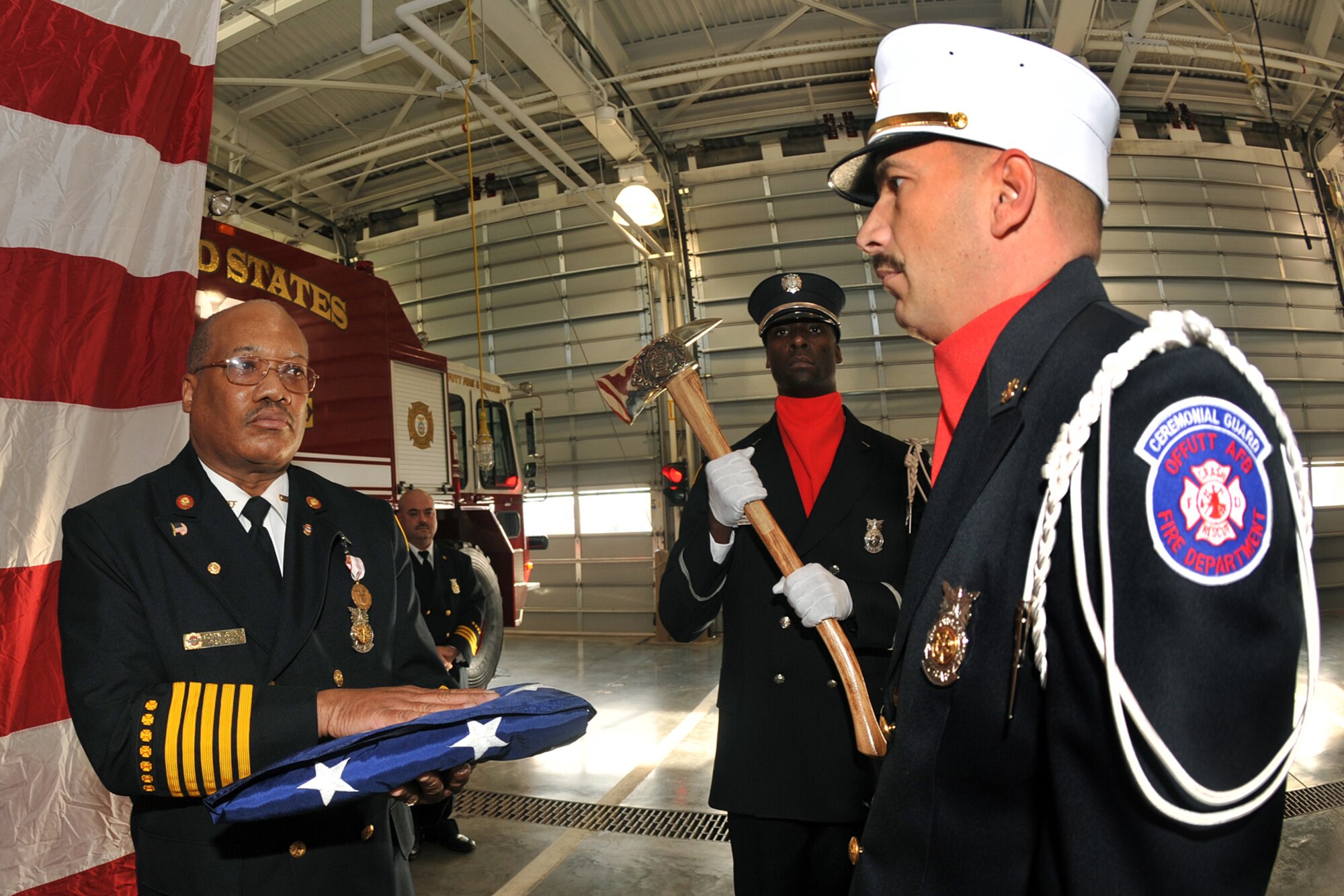 OFFUTT AIR FORCE BASE, Neb. - Members of the Offutt Firefighter Ceremonial Guard present Fire Chief Robin Gullie, 55th Civil Engineer Squadron, a U.S. flag that was folded in his honor. After 38 years of service to the U.S. Air Force and many distinguished awards, he retired Dec. 12. (Photo By: Charles Haymond). 