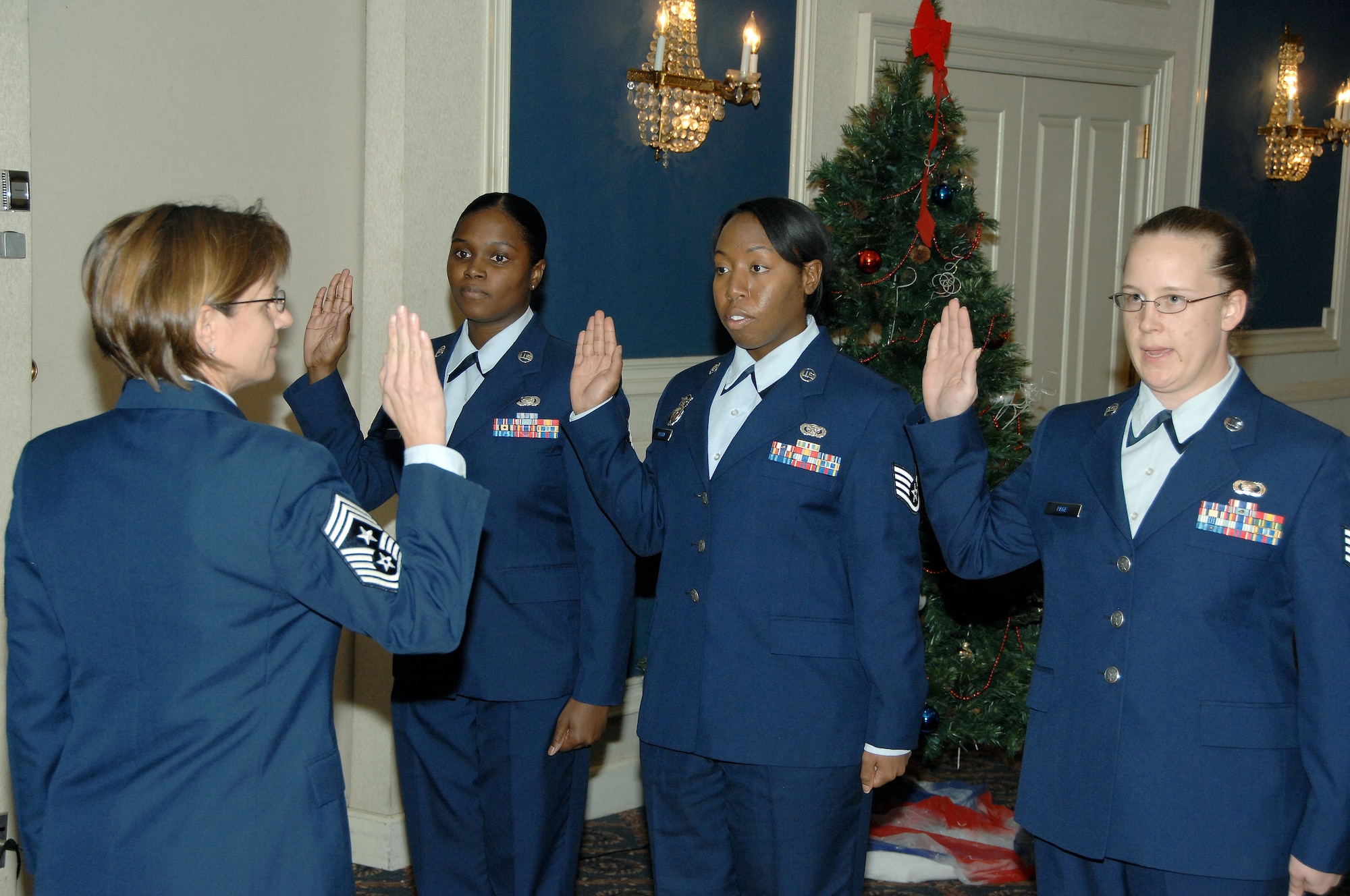 OFFUTT AIR FORCE BASE, Neb. -- 55th Wing Commmand Chief Master Sgt. Lisa A. Sirois, left, administers the Oath to three newly appointed Non-Commissioned Officers during a promotion ceremony at the Patriot Club Dec. 4. The special ceremony was held to promote and recognize all promotees in the elisted ranks at Offutt.
(U.S. Air Force Photo by Dana P. Heard)