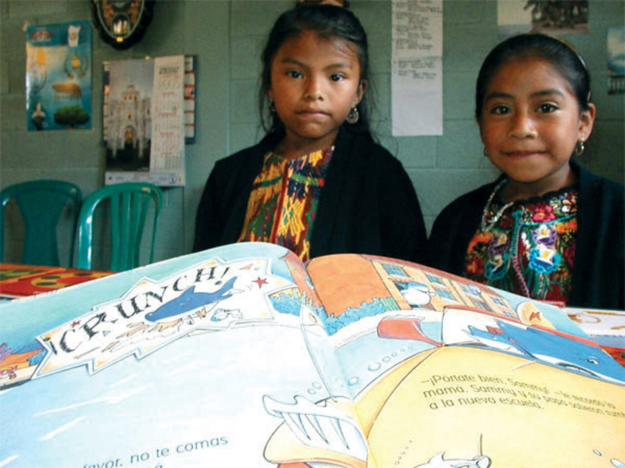 Guatemalan girls look at their new school books provided through humanitarian assistance through the U.S. Agency for International Development and delivered Dec. 5 by Airmen from Dover Air Force Base, Del. Members of the 709th Airlift Squadron here flew a C-5 Galaxy delivering 64,000 pounds of supplies to the Guatemala City International Airport to assist a Guatemalan grade school and orphanage about five hours away from the airport. The humanitarian mission was part of the Denton Program, a Department of Defense humanitarian assistance transportation program that uses space available military air, surface and sea-lift assets. The program is jointly administered by the Department of State, Defense Department and U.S. Agency for International Development. (USAID photo) 
