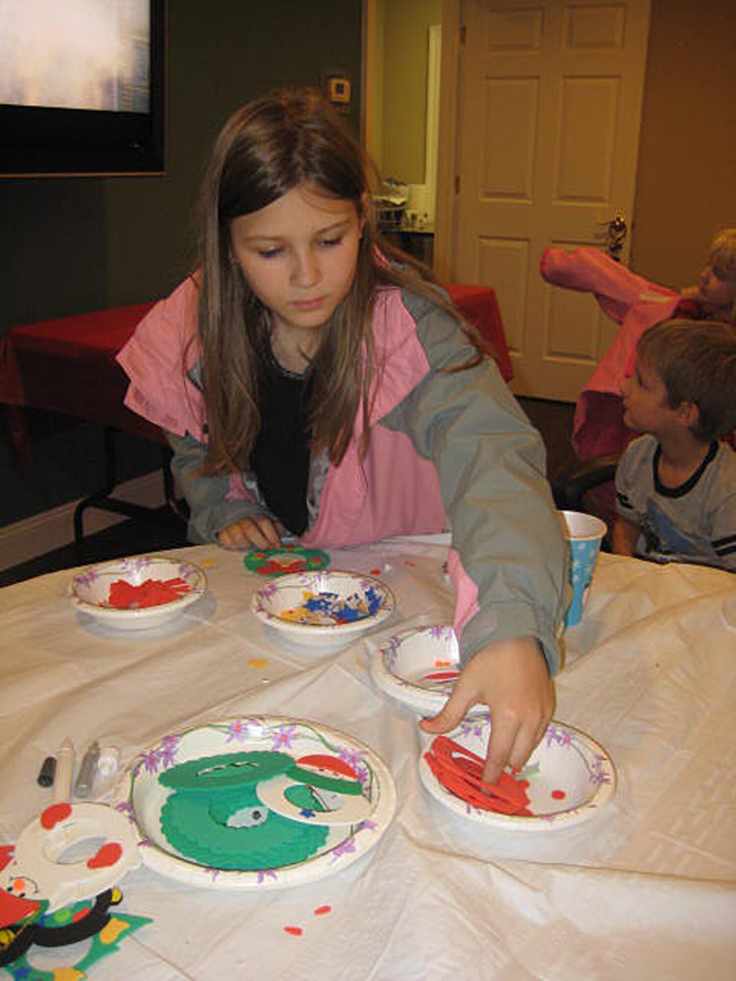 Victoria Bathe makes an ornament at the United Communities holiday craft night Dec. 10 in the leasing office. Victoria and her brother Trevor created ornaments for their deployed father's Christmas tree using their pictures. (Courtesy photo)