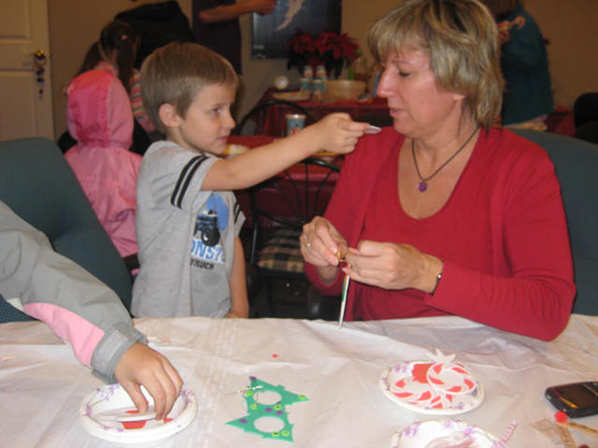Trevor Bathe shows off his creation at the United Communities holiday craft night Dec. 10 in the leasing office. Trevor and his sister Victoria created ornaments for their deployed father's Christmas tree using their pictures. (Courtesy photo)