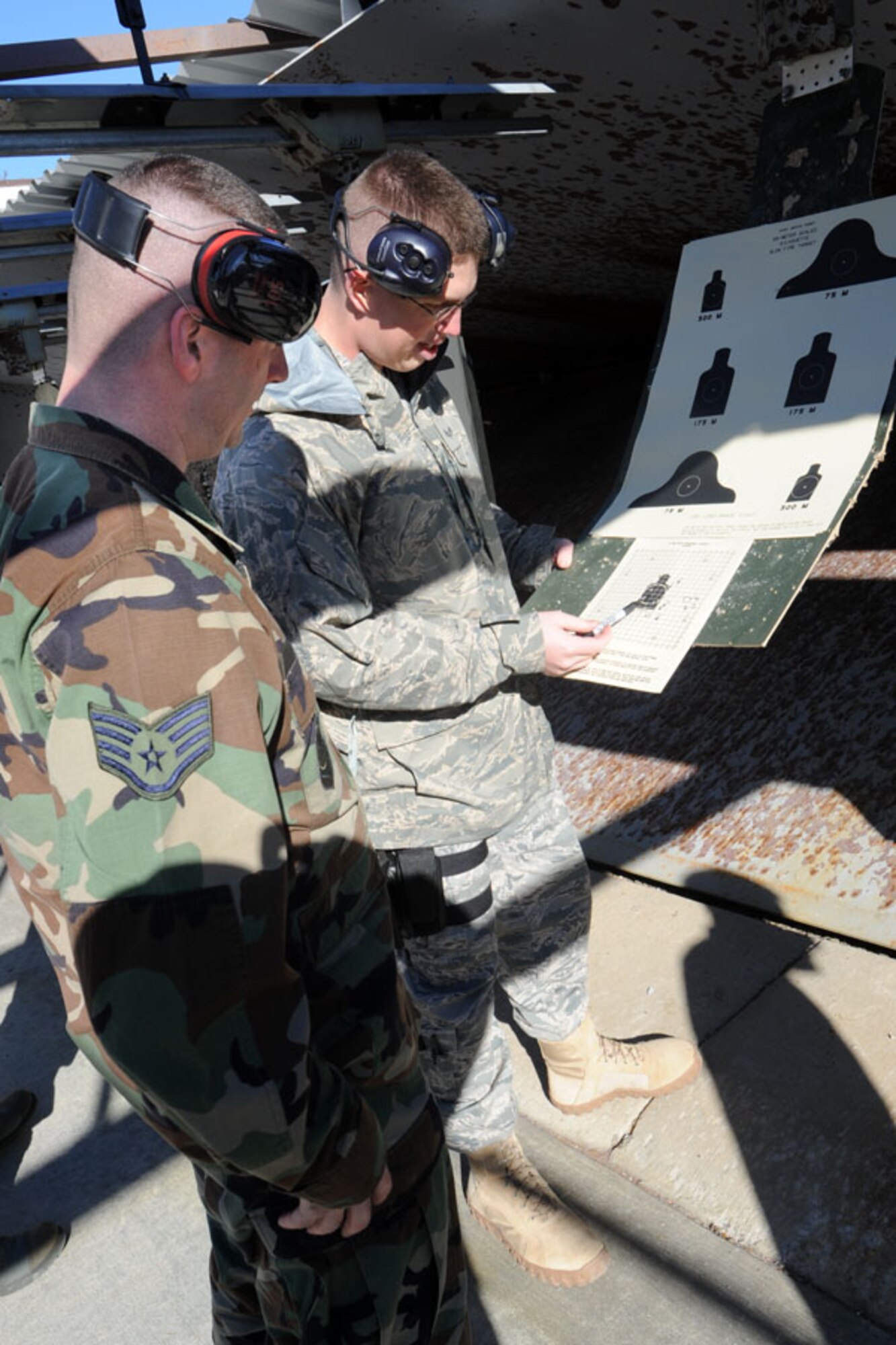 SCOTT AIR FORCE BASE, Ill. -- Senior Airman Ryan Poteet, 375th Security Forces Squadron Combat Arms instructor, reviews the score of trainees and gives tips on how to improve them, as well as, make adjustments to the rifle sighting to improve accuracy. 

(U.S. Air Force photo/Senior Airman Jonathan Lovelady)