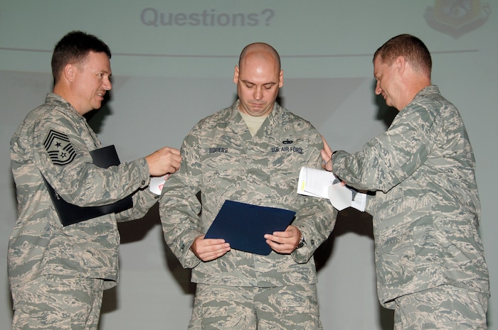 Master Sgt. Roy Rogers receives a Stripes for Exceptional Performers promotion from Col. John "Red" Millander and Chief Master Sgt. Mike Ivey during a wing Commander's Call Dec. 12 at the base theater. The Air Force releases less than 200 STEP promotion slots annually to promote outstanding individuals to staff, technical or master sergeant. Colonel Millander is the 437th Airlift Wing commander, Chief Master Sergeant Ivey is the 437 AW command chief and Sergeant Rogers is assigned to the 437th Logistics Readiness Squadron. (U.S. Air Force photo/Staff Sgt. Marie Cassetty)