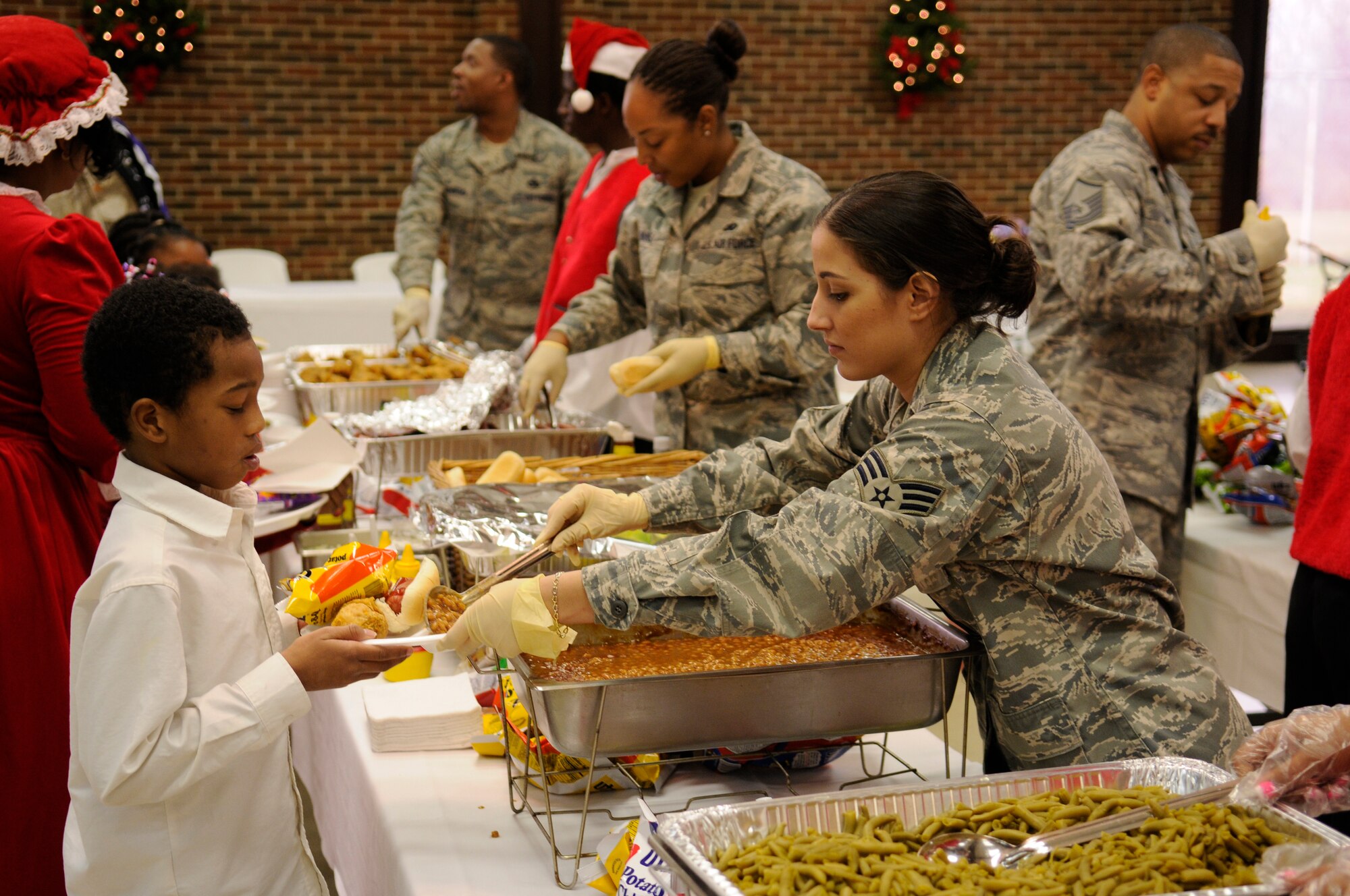 Senior Airman Dessie Centeno-Lopez, 11th Logistics Readiness Squadron, serves lunch to an elementary school student during the 39th annual 7th District Christmas Party Dec. 12 in Washington. Eighteen Airmen from Bolling AFB and the Pentagon volunteered to put shoes on the feet of 220 children, serve food, wrap gifts and clean up. (U.S. Air Force photo by Staff Sgt. Dan DeCook)