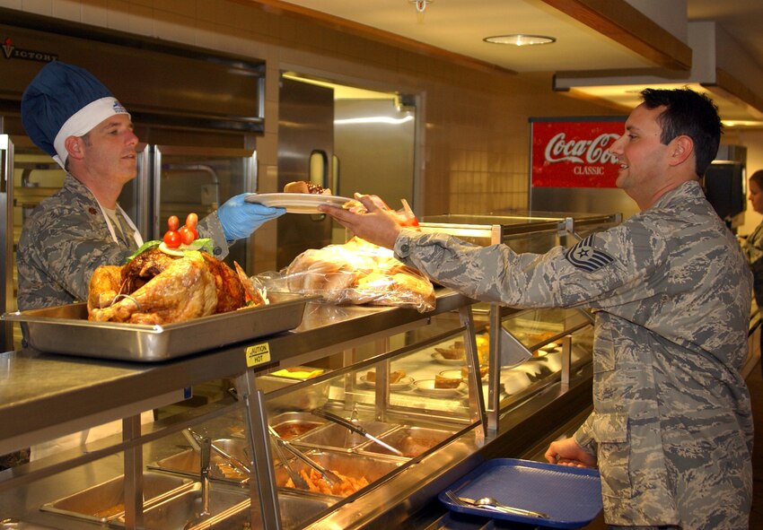 In the spirit of the holiday season, Maj. Jason Haynes, left, 919th Maintenance Operations Flight commander, serves holiday meals to reservists Dec. 7 in the base dining facility during the unit training assembly.  Major Haynes served up a special holiday meal along with several other commanders and senior NCOs at Duke Field. The leadership served for more than two hours while continuously encouraging reservists for their hard work and wished them happy holidays. (U.S. Air Force photo by Rick Clifton)