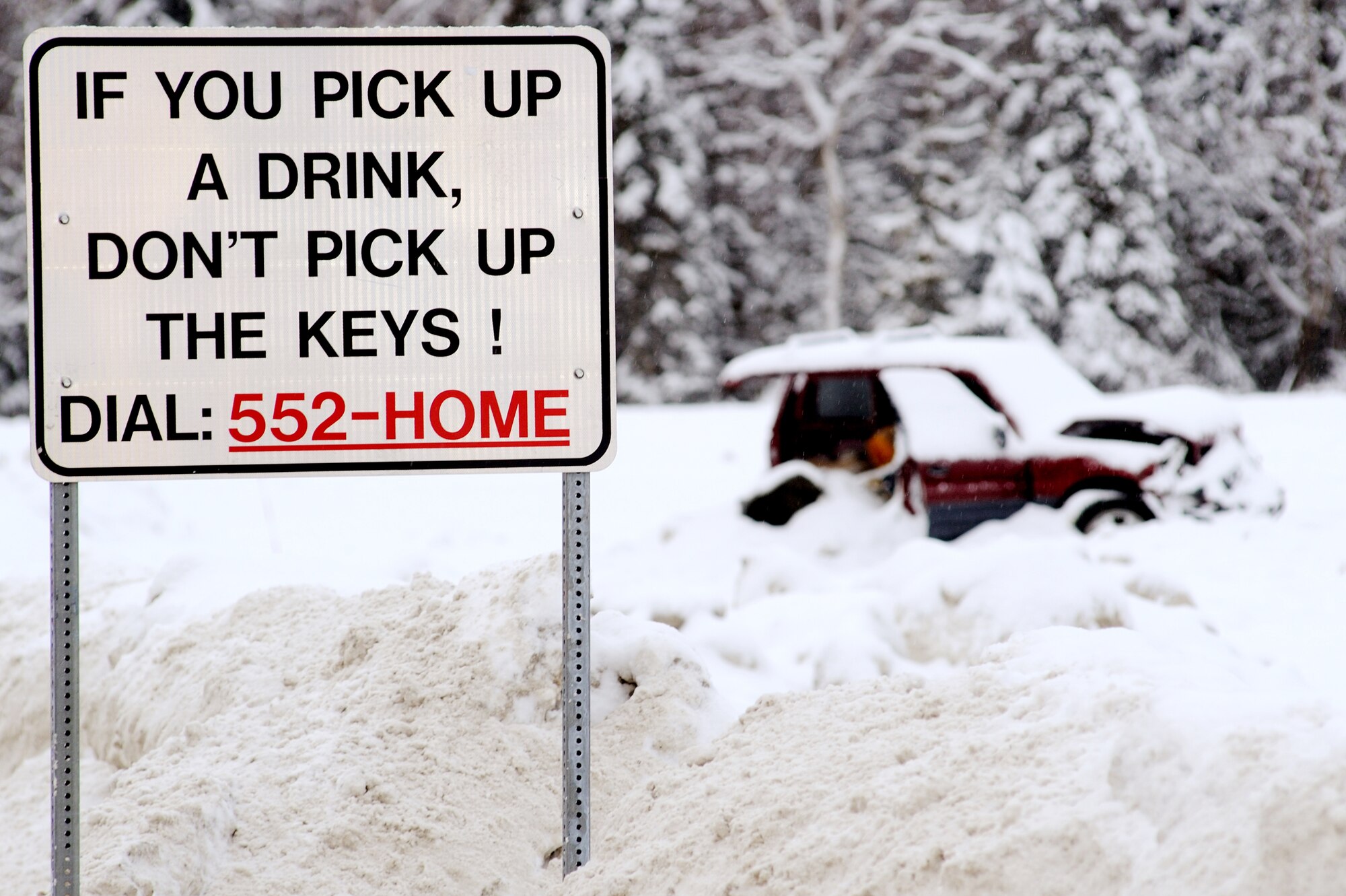 ELMENDORF AIR FORCE BASE, Alaska -- A wrecked sport utility vehicle sits in the background of the newly placed Airmen Against Drunk Driving sign inside the Boniface Gate. This display is a visual demonstration of the possibilities of driving under the influence. For more information, call the 3rd Wing Safety Office at 552-3934. (U.S. Air Force photo/Airman 1st Class Kristin High)