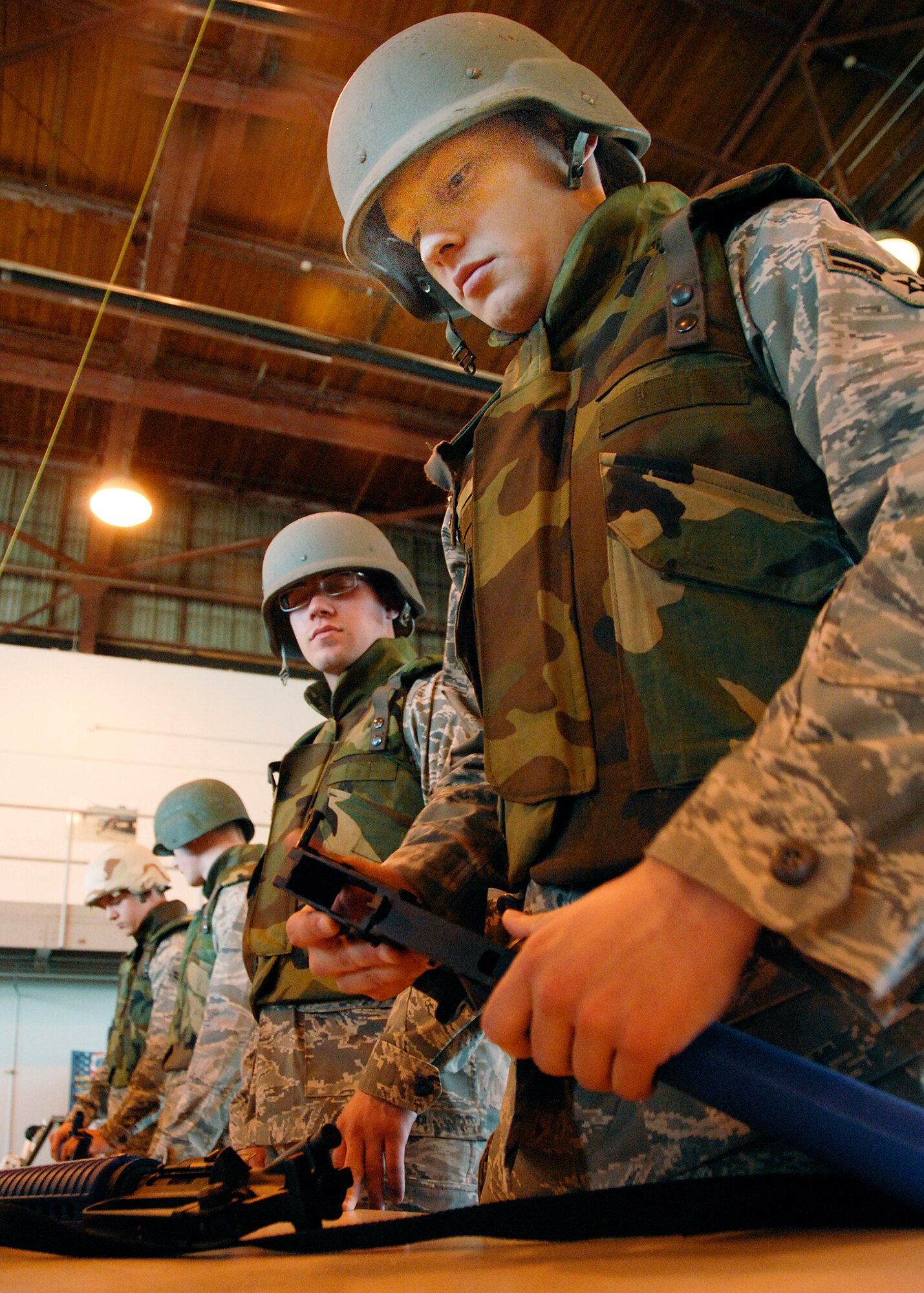 Crew chief student Airman Andrew Lynn watches fellow 362nd Training Squadron student Airman 1st Class Joshua Douglas put together his M-16 during a timed trial as part of Combat Skills Training Dec.12. The 362nd TRS implemented combat training into their Air Force specialties to prepare the future flight crew chiefs for deployments. (U.S. Air Force photo/Harry Tonemah)
