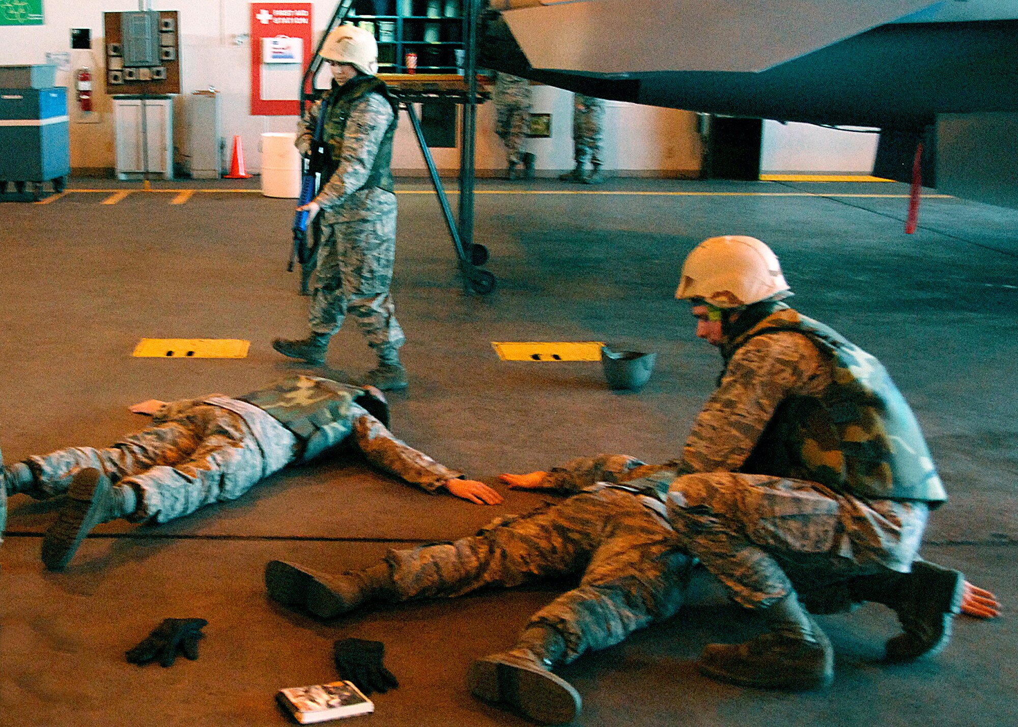 Crew chief student Airman 1st Class Heather Hernandez holds and M-16 on an intruder while student Airman Cedrick Calza searches the two intruders during a walking guard duty exercise in Combat Skills Training Dec.12. The 362nd TRS implemented combat training into their Air Force specialties to prepare the future flight crew chiefs for deployments. (U.S. Air Force photo/Harry Tonemah)