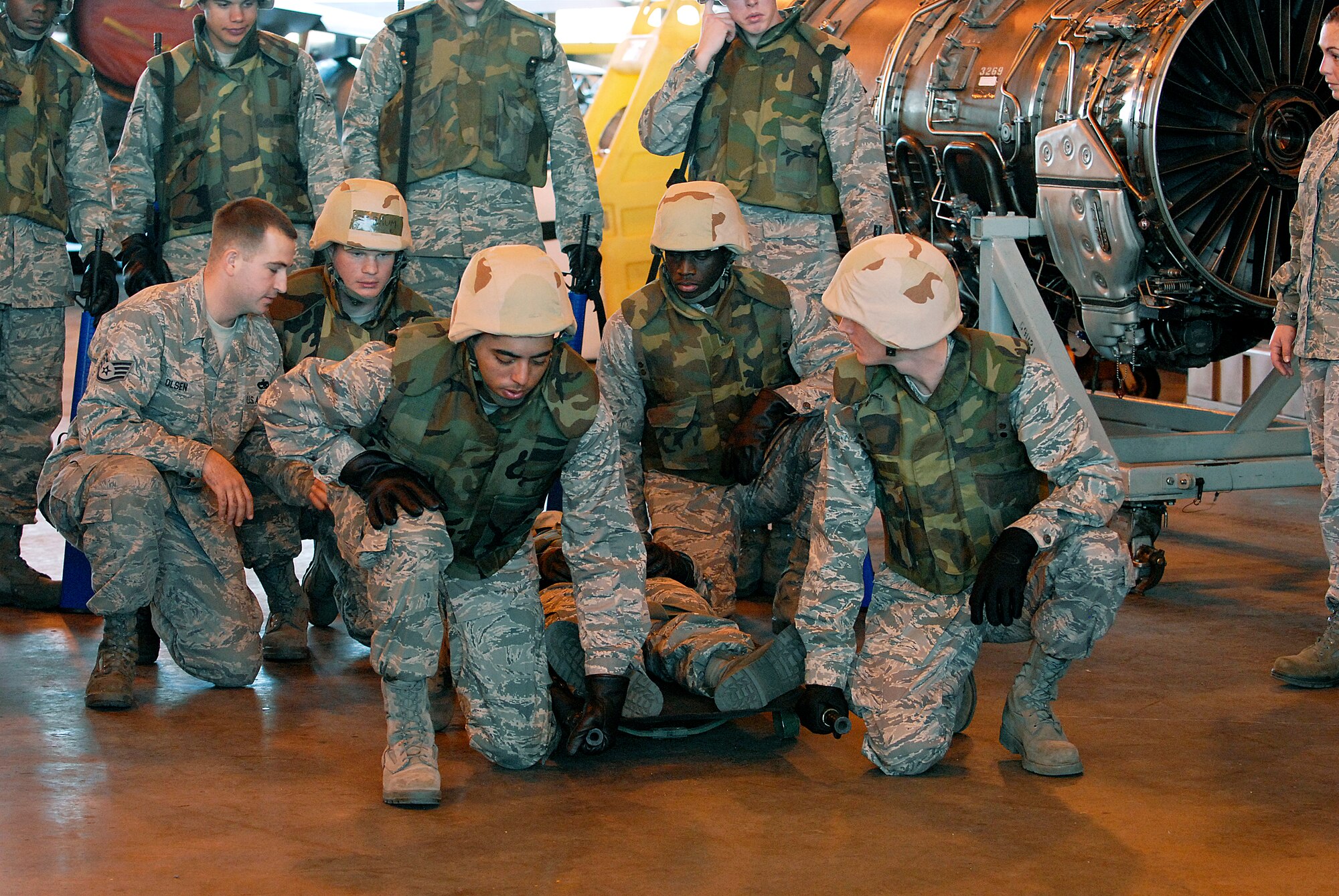 Staff Sgt. Richard Olsen, a 362nd Training Squadron instructor, trains students Airman Steven Wilson, Airman Ryan Mercado, Airman Stanley Hall and Airman Phillip Sneed on how a four man team should prepare an injured person to be carried on a litter in the field at the Combat Skills Training Dec.12. The patient David Silvas said they did very well. The 362nd TRS implemented combat training into their Air Force specialties to prepare the future flight crew chiefs for deployments. (U.S. Air Force photo/Harry Tonemah)