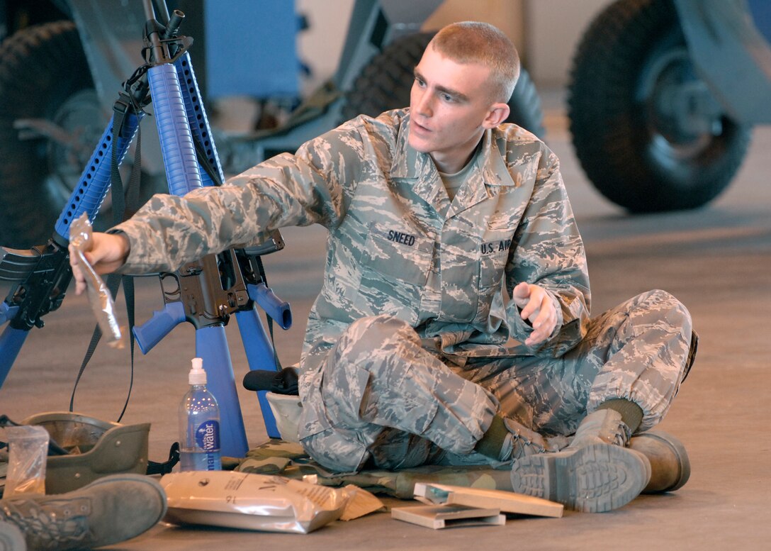 Airman Phillip Sneed tries to share his Meals Ready to Eat with another Airman during their lunch break at Combat Skills Training Dec.12. The 362nd Training Sqaudeon implemented combat training into their Air Force specialties to prepare the future flight crew chiefs for deployments. (U.S. Air Force photo/Harry Tonemah)