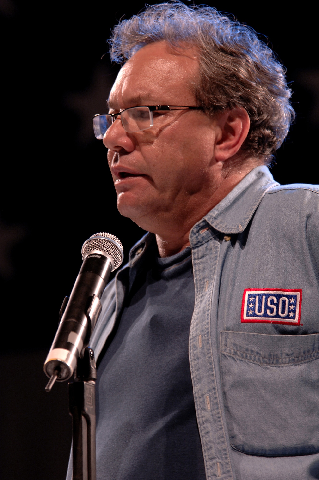 Lewis Black performs during the United Service Organizations (USO) Holiday Tour stop in Hanger 1 at Ramstein Air Base, Germany, Dec. 16, 2008. Other USO entertainers included Kid Rock and Kelly Pickler. (U.S. Air Force photo by Airman 1st Class Kenneth Holston)