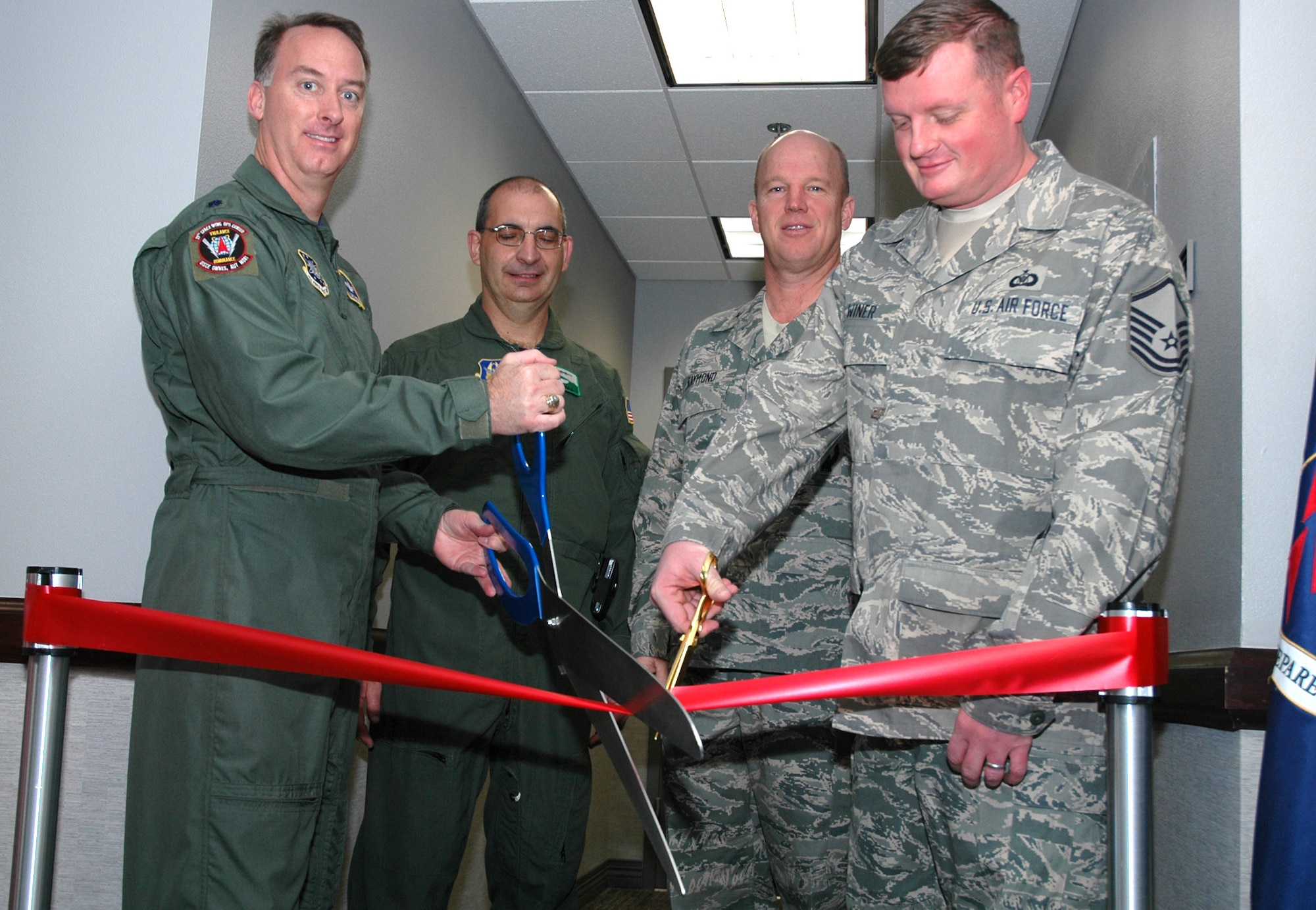 (Left to right): Lt. Col. Marc Peterson, Col. James J. Muscatell, Jr., Col. Jay Raymond and Master Sgt. Jason Winer cut the ribbon Dec. 16, 2008, to the newly-combined Peterson Installation Control Center at Peterson Air Force Base, Colo. The combined control center, an Air Force Smart Operations-21 initative, consolidates active duty and Air Force Reserve command post resources into one location. The streamlined efforts allow for more experienced reservists to mentor their active duty counterparts while allowing the active duty Airmen to enhance their skills with both space and aircraft-related command post duties. Colonel Peterson is the PICC's director, Colonel Muscatell is commander of the 302nd Airlift Wing, Colonel Raymond is commander of the 21st Space Wing and Sergeant Winer is a 302nd AW command post technician. (U.S. Air Force photo/Stephen J. Collier)