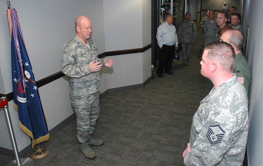 Col. Jay Raymond addresses guests before the Dec. 16, 2008 dedication of the newly-combined Peterson Installation Control Center at Peterson Air Force Base, Colo. The combined control center, an Air Force Smart Operations-21 initative, consolidates active duty and Air Force Reserve command post resources into one location. The streamlined efforts allow for more experienced reservists to mentor their active duty counterparts while allowing the active duty Airmen to enhance their skills with both space and aircraft-related command post duties. Colonel Raymond is commander of the 21st Space Wing. (U.S. Air Force photo/Stephen J. Collier)