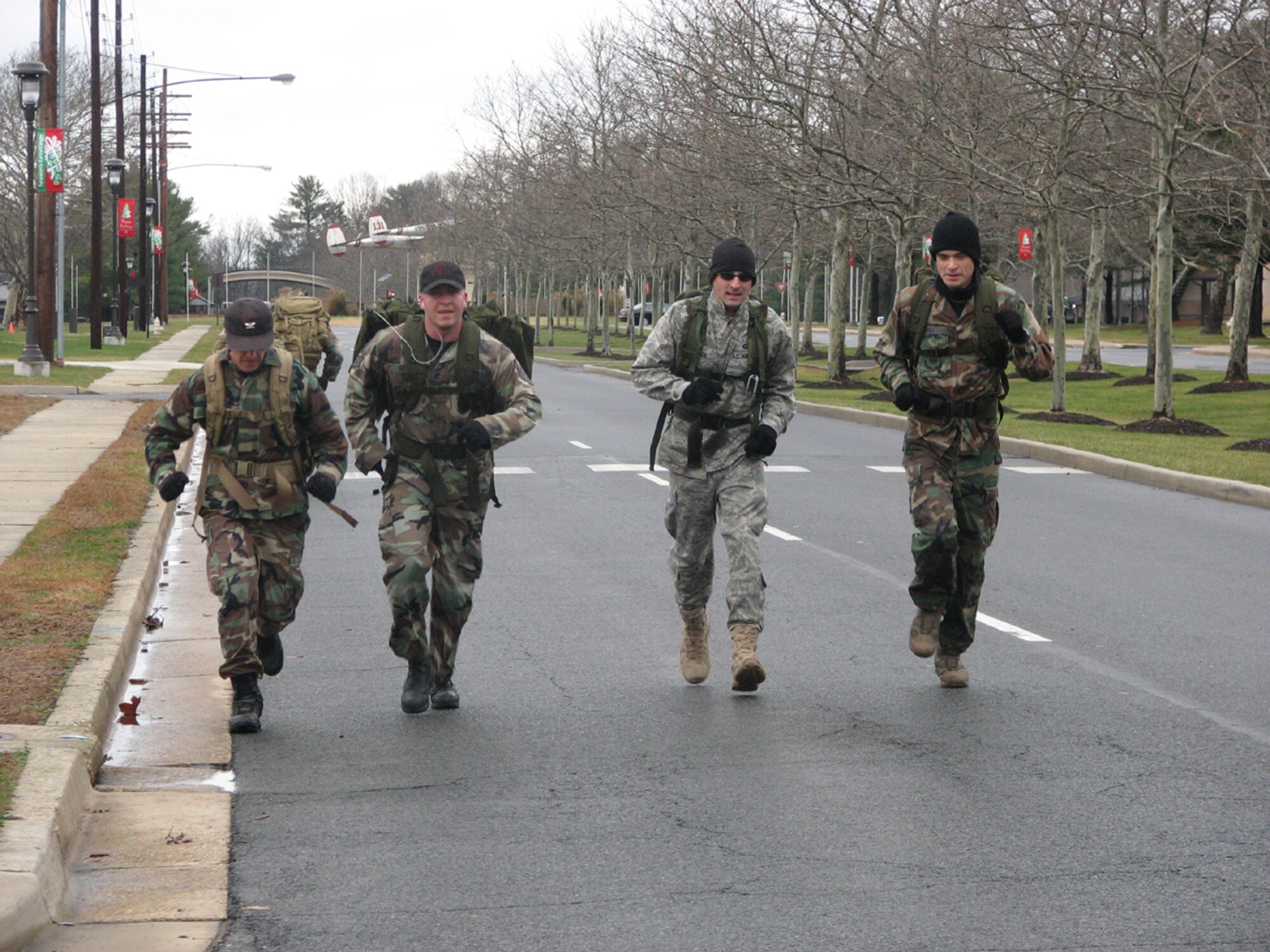 (From left to right) Col. Mark Ellis, Staff Sgt. Charles Bina, Lt. Col. Jeff Fallesen, and Maj. Mark Jones charge towards the finish line and claim first place for the 817th Contingency Response Group's ruck march team during the 621st Contingency Response Wing's Combat Sports Day, Dec. 12.  The day consisted of a combat relay, ruck march, weapons assembly, land navigation, pallet build-up, volleyball and tug-of-war. Teams were awarded points based on their finish in each event. (U.S. Air Force photo/1st Lt. Dustin Doyle)