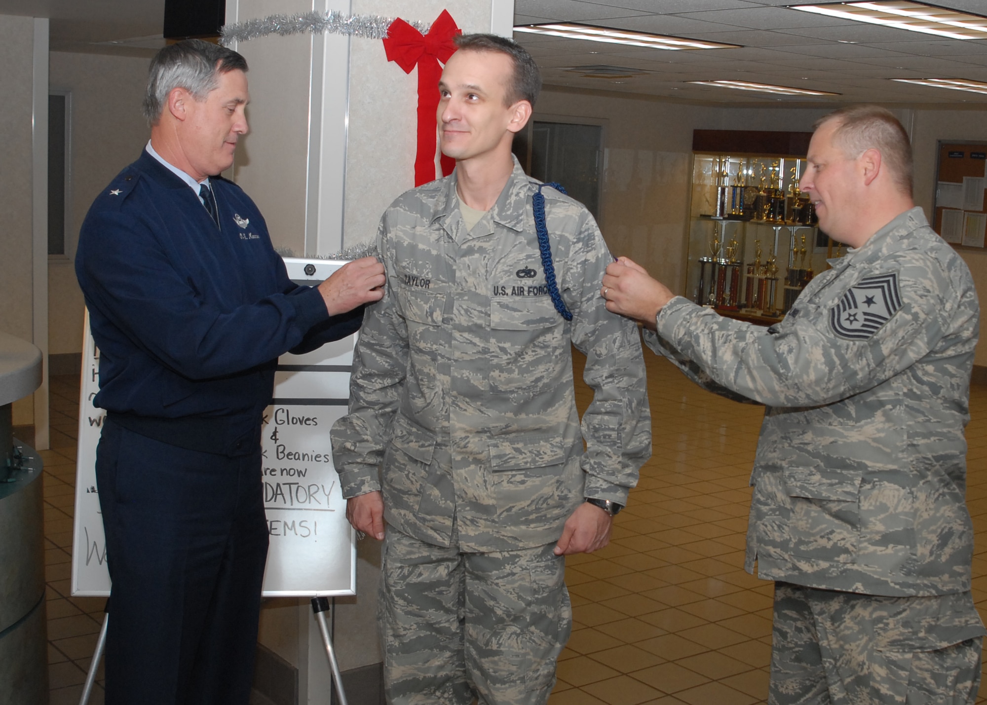 Brig. Gen. O.G. Mannon, 82nd Training Wing commander, and Command Chief of the 82nd TRW Chief Master Sgt. Kenneth Sallinger, promote Kevin Taylor, assistant flight chief at the 364th Training Squadron, to master sergeant with Stripes for Exceptional Performance Dec. 12. STEP promotions allow the ranks of staff sergeant to master sergeants to be promoted to the next rank without going through standard testing procedures. (U.S. Air Force photo/Lou Anne Sledge)