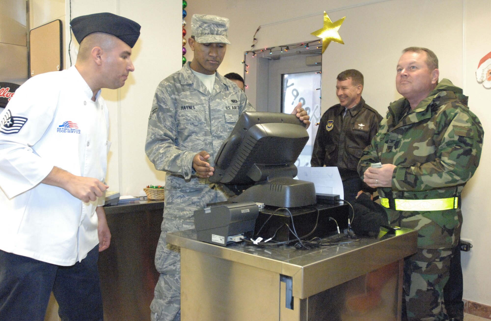 Tech Sgt Manuel Gayton and Airman 1st Class Shaun Haynes of the 31st Force Support Squadron work together to serve Col. David Coomer, 31st Maintenance Group commander, during the grand opening of the La Dolce Vita Dining Facility's Grab-n-Go Flight Kitchen Dec. 15. The kitchen is geared toward serving those Airmen who don't have enough time to dine-in for a hot meal at the dining facility. The expanded service also allows maintainers and flight line personnel to stay in their flight line duty attire to pick-up their meals. The flight kitchen will offer grab-n-go meals from 11 a.m. to 9 p.m. and hot meals to go from 11 a.m. to 1 p.m. and 5-7 p.m. Customers can also call in or fax orders for five people or more in advance. (U.S. Air Force photo/Staff Sgt. Lindsey Maurice)