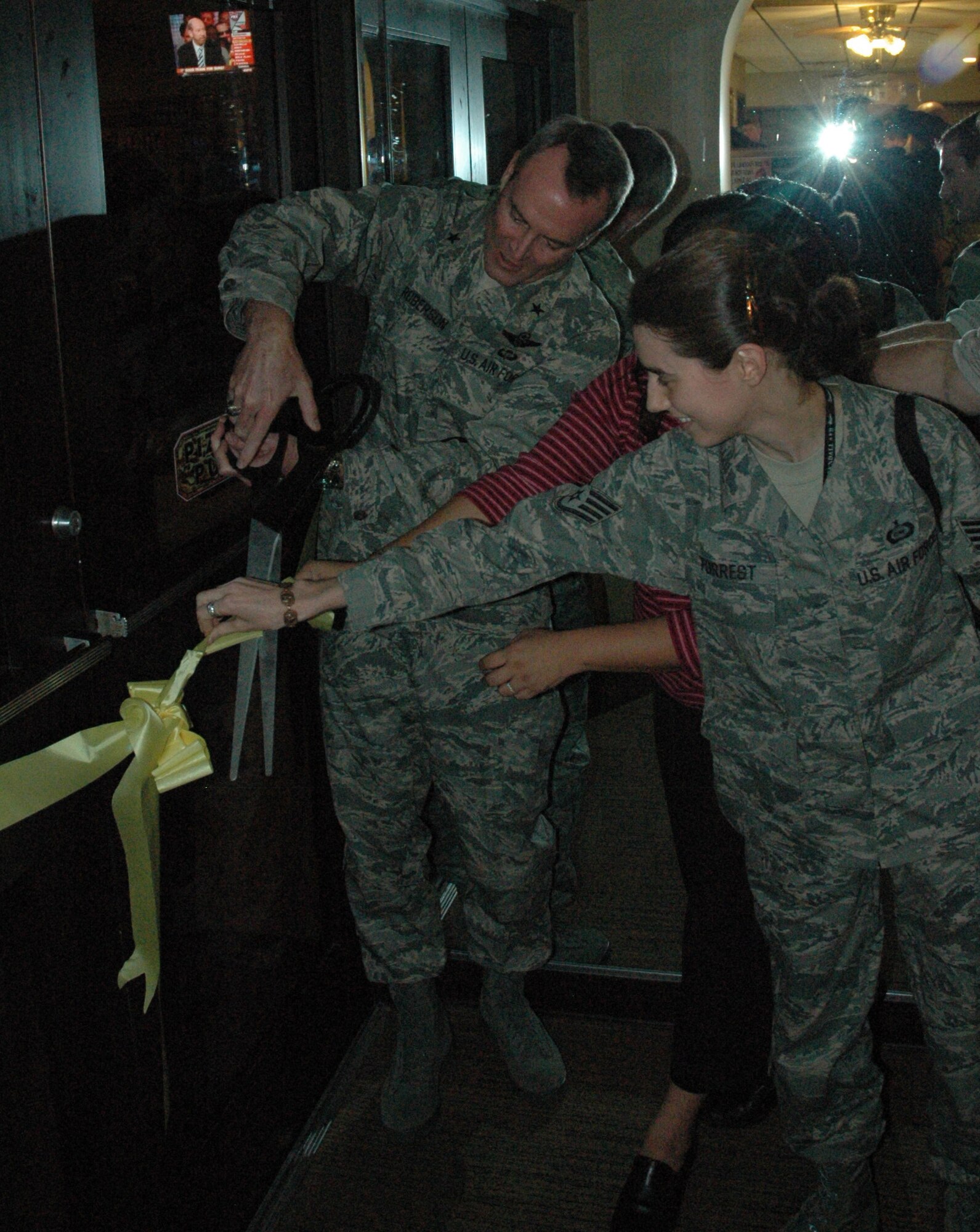 Brig. Gen. Darryl Roberson cuts the ribbon at the new Sports Enlisted Lounge in the Community Activity Center Dec. 11.  New billiards tables and many various sports jerseys hang from the walls to give the pizza pub a more sports bar environment for enlisted members.  (U.S.  Air Force photo taken by Senior Airman Anthony J. Hyatt)