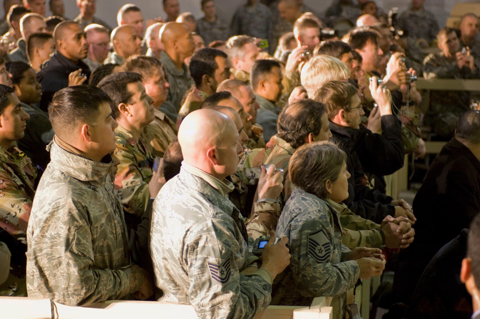 Airmen, joined by other U.S. and Coalition servicemembers, listen to a speech by President George W. Bush at Bagram Air Field, Afghanistan, Dec. 15. During his final visit to Afghanistan as commander in chief, President Bush thanked all the servicemembers for their service, especially during the holiday season. (U.S. Air Force photo by Staff Sgt. Rachel Martinez) (Released)