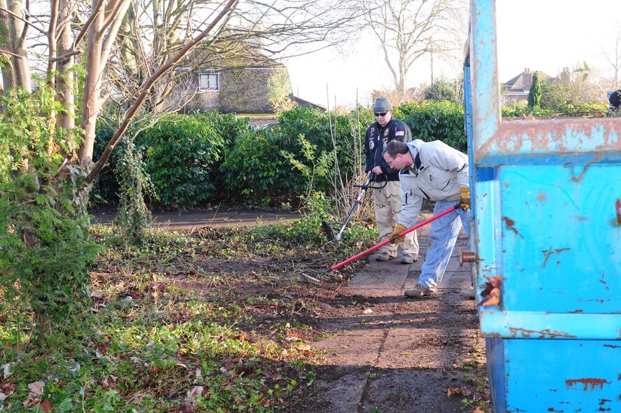 Tech. Sgt. Patrick Storer, front, and Staff Sgt. Josh Warner, both 95th Reconnaissance Squadron, rake and strim an area outside Riverside Middle School, Mildenhall, Dec. 11. Forty-three volunteers from the 95th RS spent the morning clearing undergrowth, dead and overgrown trees, leaves and rubbish from the exterior grounds of the local school. This is the second year they have volunteered and helped the school. In 2007, they cleared five years-worth of undergrowth from the area. Headteacher, Caroline Yates, said the 95th RS volunteers saved the school between £4,000 and £5,000, which can now be spent on other school activities. (U.S. Air Force photo by Karen Abeyasekere)