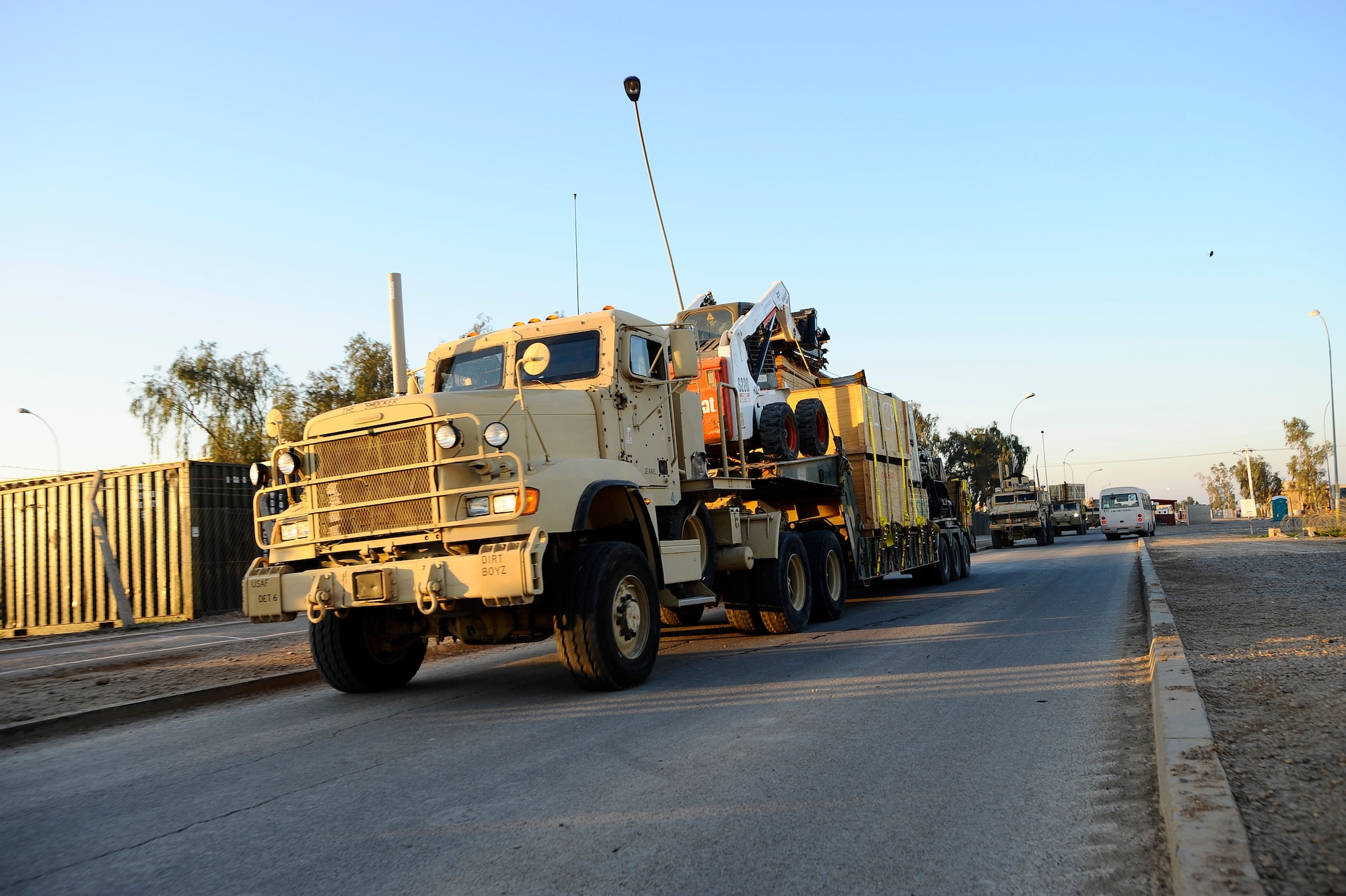 A Mine-Resistant Ambush-Protected vehicle and Heavy Expanded Mobility Tactical Truck convoy down a road at Joint Base Balad, Iraq, Dec. 11. Airmen with the 732nd Expeditionary Civil Engineer Squadron Detachment 6 undertake outside-the-wire construction projects for the Army. (U.S. Air Force photo/Airman 1st Class Jason Epley)