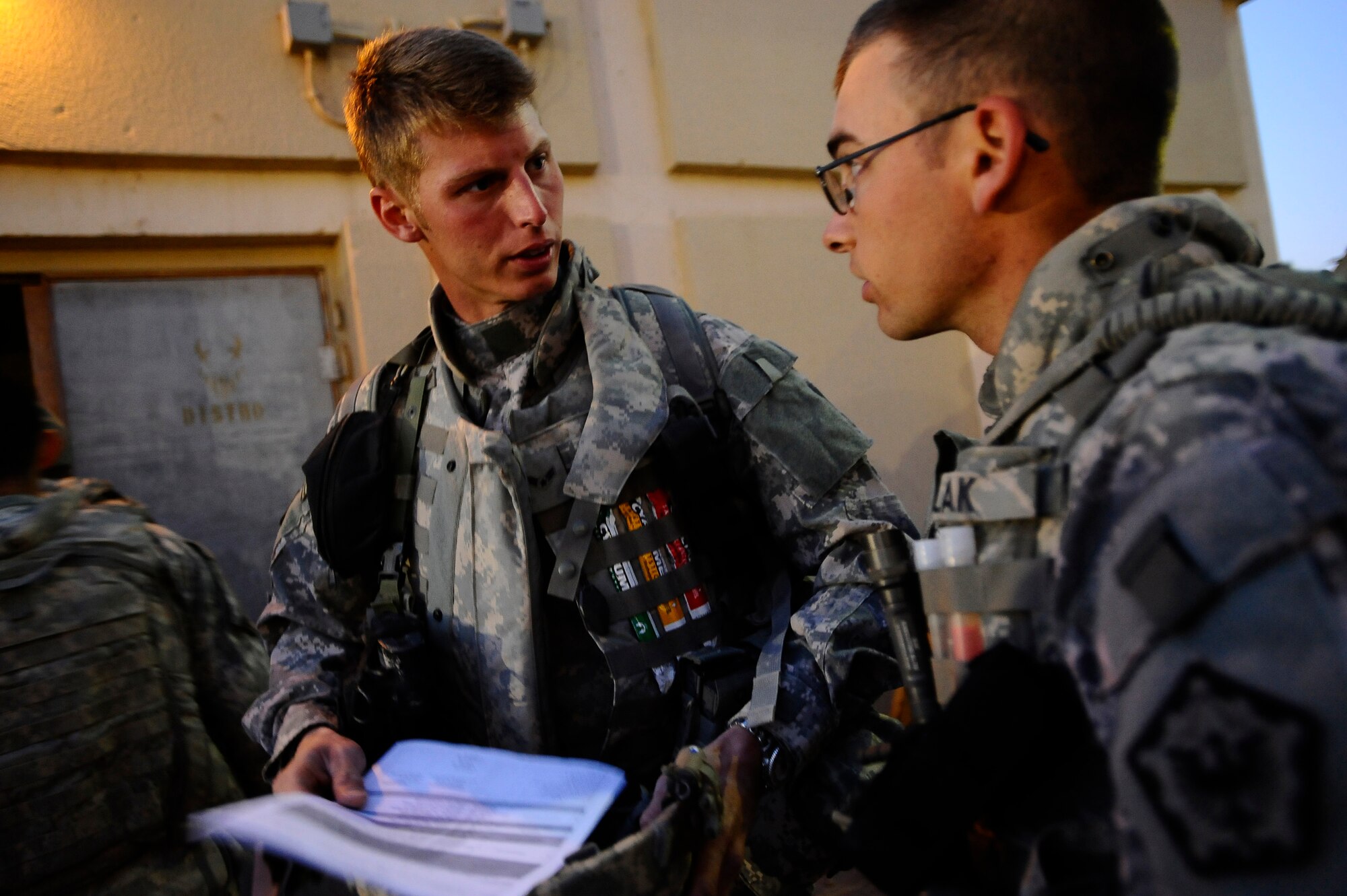 Airmen 1st Class Tim Wynne and Kenneth Bulak discuss a briefing at Joint Base Balad, Iraq, prior to an outside-the-wire mission Dec. 11. Wynne and Bulak are assigned to the 732nd Expeditionary Civil Engineer Squadron Detachment 6, which undertakes construction projects for the Army. Wynne, a structural engineer and native of York, Pa., is deployed from Yokota Air Base, Japan. Bulak, a pavements and equipment operator and native of Warren, Mass., is deployed from Hickam Air Force Base, Hawaii. (U.S. Air Force photo/Airman 1st Class Jason Epley)