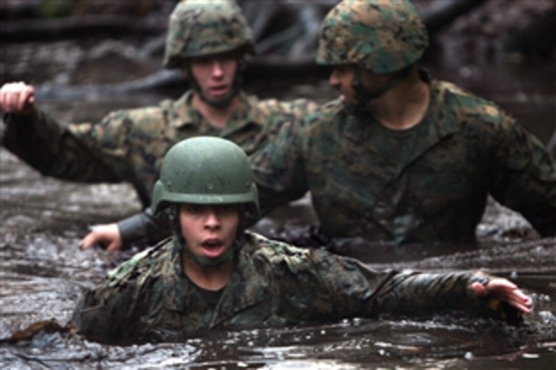 U.S. Marine Corps Sgt. Christine Rivera leads fellow Marines through one of the Battle Skills Training School Endurance Course's murky swamps on Marine Corps Base Camp LeJune, N.C., Dec. 12, 2008. Rivera, a financial management resource analyst, is assigned to 2nd Marine Logistics Group Comptroller. 