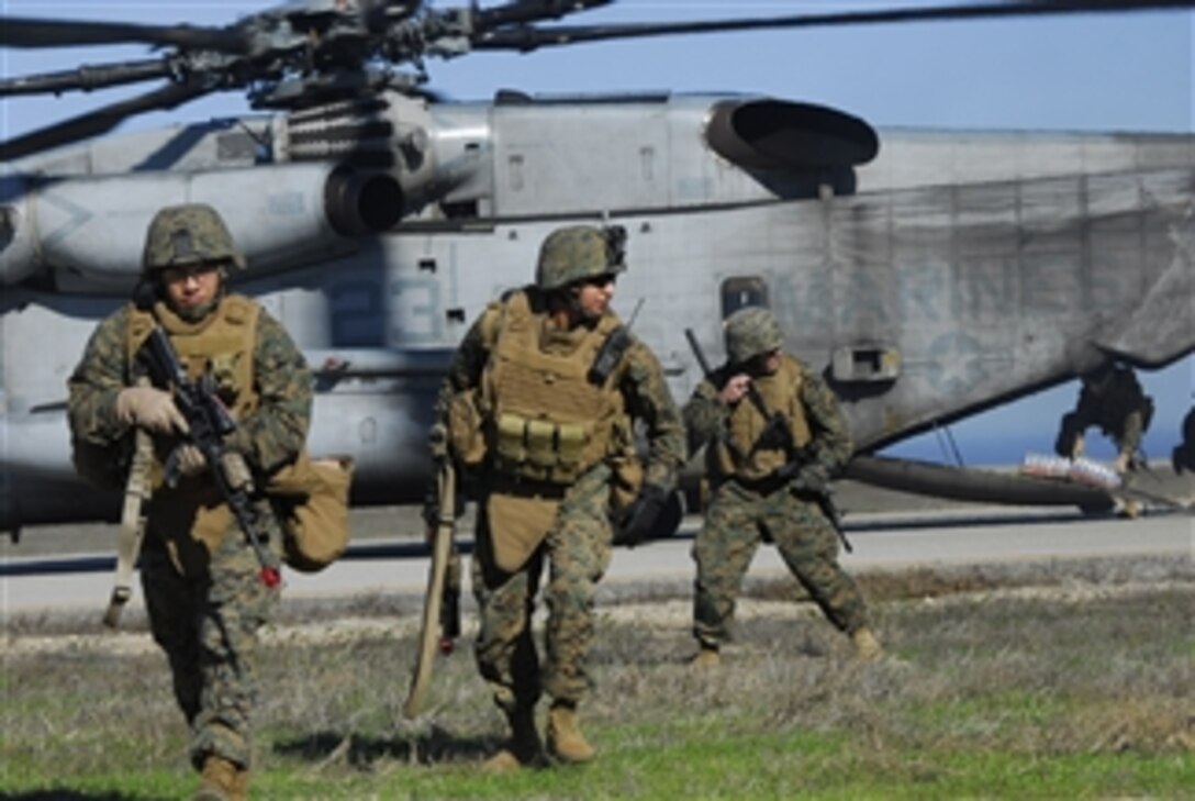 U.S. Marines with Charlie Company, 1st Battalion, 1st Marine Regiment, 13th Marine Expeditionary Unit run towards their security positions while fellow Marines offload food and water from an aircraft during a humanitarian assistance survey team scenario on San Nicholas Island, Calif., on Dec. 9, 2008.  The 13th Marine Expeditionary Unit is conducting a certification exercise to prepare for an upcoming deployment.  