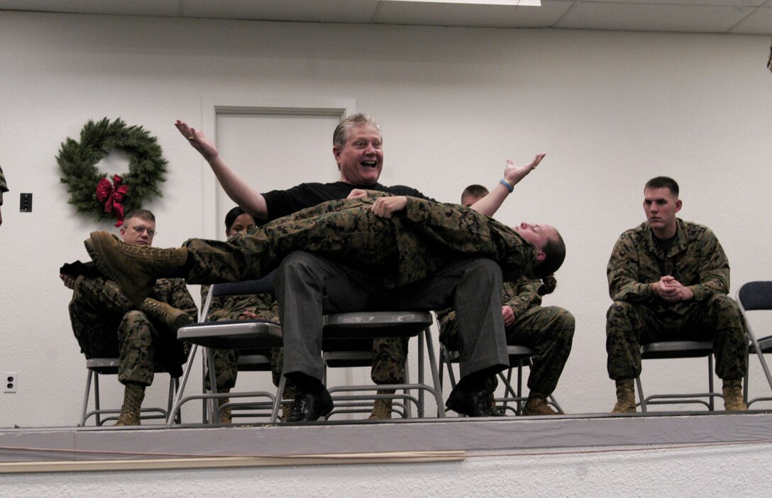 CAMP H.M. SMITH, Hawaii -- Comedian Ken Whitener demonstrates the power of hypnosis by having Lance Cpl. Jessica Perry, MarForPac combat lithographer, make her body straight as a board and strong enough for him to stand on under hypnosis during the 2008 Holiday Fun Safety Stand Down Dec. 17.