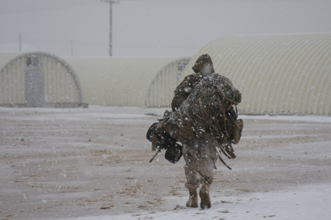 A lone Marine from 1st Battalion, 7th Marine Regiment, trudges through snow at the Combat Center’s Camp Wilson after returning from a cancelled field exercise Wednesday, Dec. 17, 2008, during the second of two snow storms which hit the entire Morongo Basin.