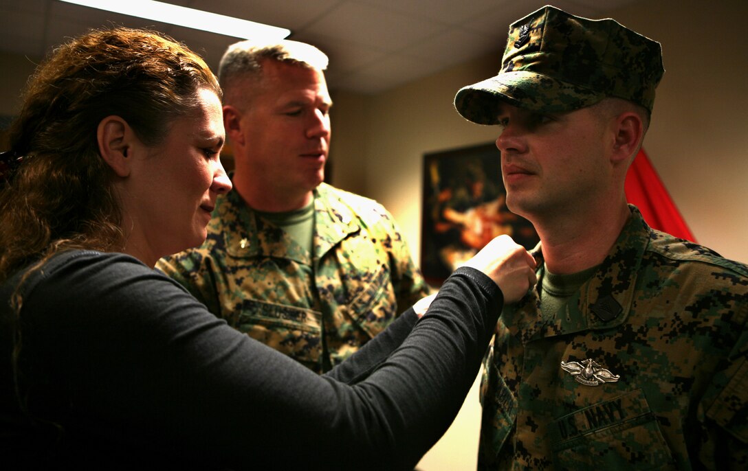 Petty Officer 1st Class Ryan Faulhaber's wife places new rank insignia on her husband's collar during his combat meritorious promotion, here, Dec. 17.  According to the U.S. Navy's Combat Meritorious Advancement Program, only one sailor is combat meritoriously promoted to the rank of petty officer first class each quarter in U.S. Central Command.
