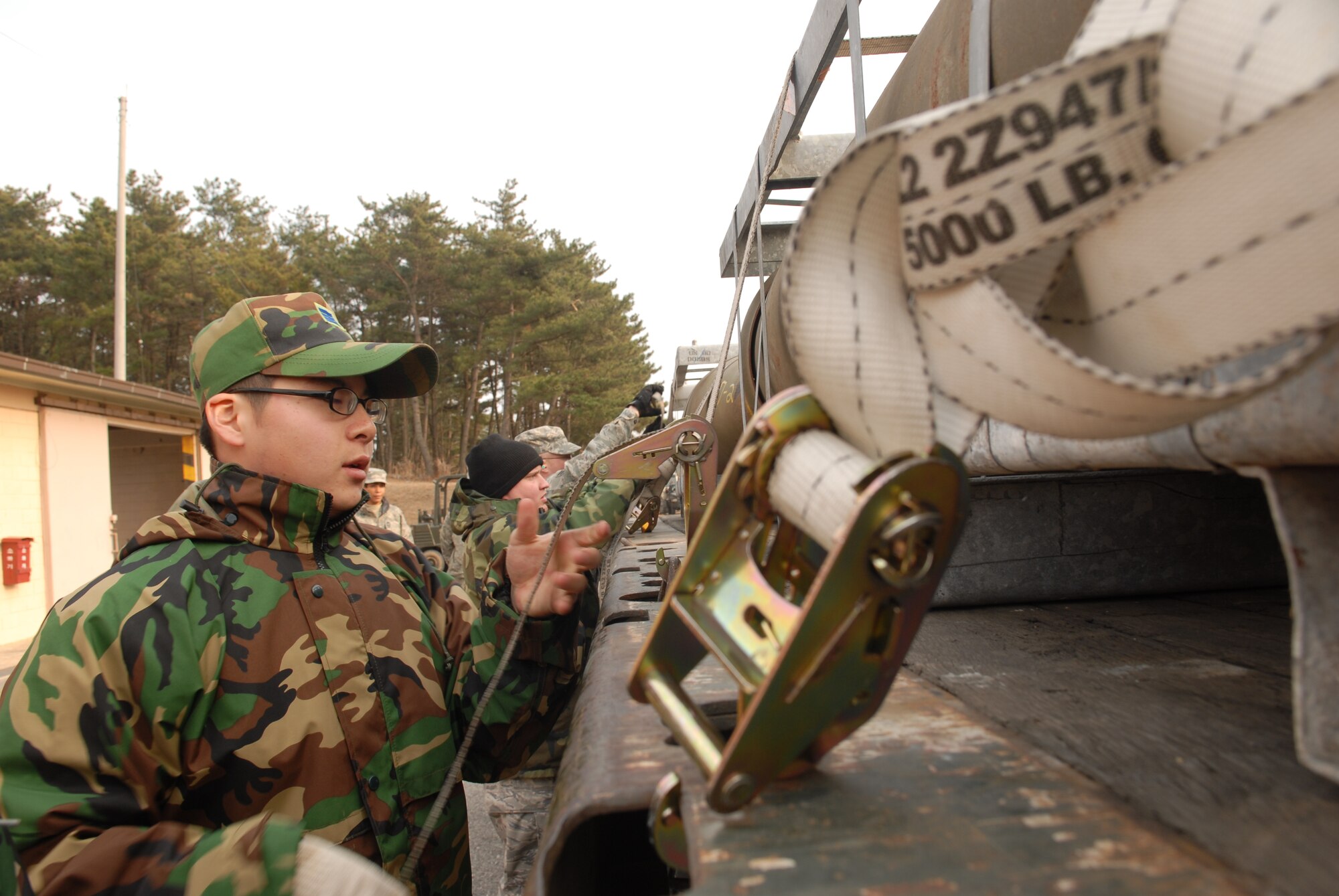 KUNSAN AIR BASE, Republic of Korea -- Republic of Korea Air Force Staff Sgt. Jong Mun Park, secures a load of MK-84 general purpose bombs to a 10 ton tractor trailer here Dec. 17. USAF and ROKAF Airmen work and train together regularly at Kunsan.(U.S. Air Force photo by: Senior Airman Angela Ruiz) 
