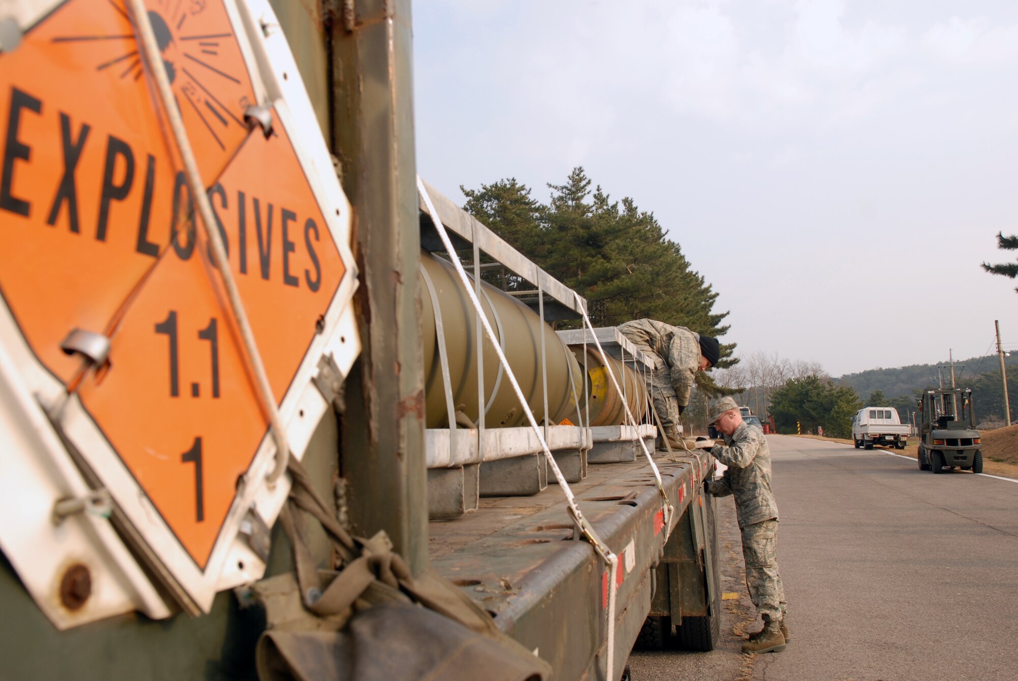 KUNSAN AIR BASE, Republic of Korea -- Airmen 1st Class Michael Patterson and Brittany Huffman, 8th Maintenance Squadron, secure a load of MK-84 general purpose bombs to a 10 ton tractor trailer here Dec. 17.(U.S. Air Force photo by: Senior Airman Angela Ruiz) 