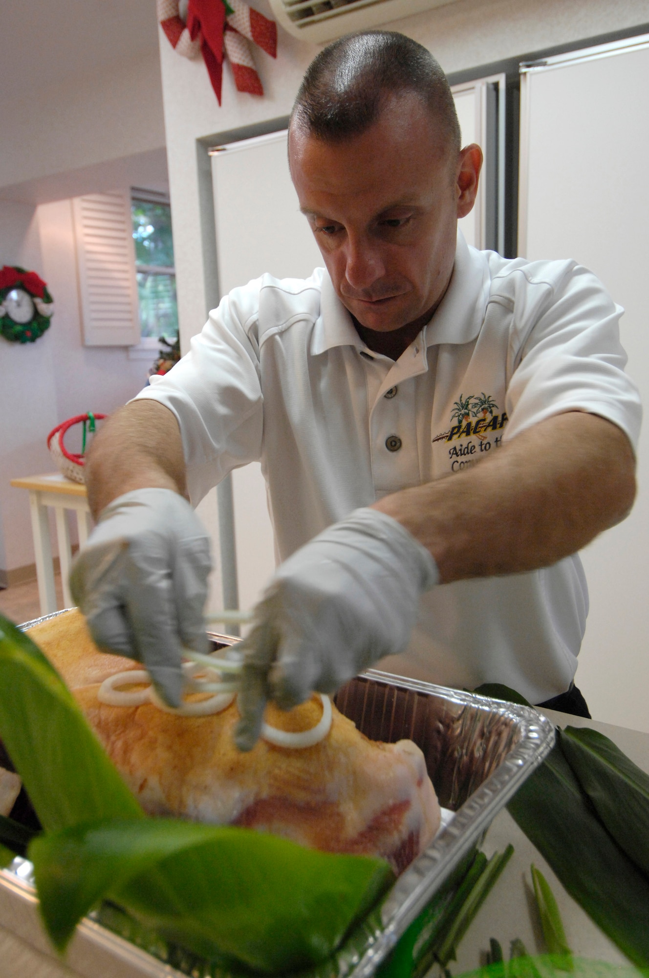 Department of Defense 2008 Enlisted Aide of the year winner, Master Sgt. Craig Duclos, the MAJCOM Fuctional Manager for enlisted aides in the pacific and the Senior Enlisted Aide to Pacific Air Forces Commander Gen. Howie Chandler, adds the last bit of flavoring for his roast pork recipe in preparation for a party at the house of Gen. Chandler on Dec. 12, 2008. Cooking is just one of the many tasks that Master Sgt. Duclos performs on a daily basis; he also coordinates the care of the lawn, prepares the General's bags for trips, works closely with the catering staff of the Officer's Club, schedules appointments, cleans house, goes food shopping and picks up dry cleaning. (U.S.  Air Force photo by Tech Sgt. Cohen A. Young) 