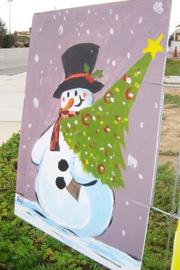 Staff Sgt. Al Dupont, 163 RW/ SVF, was the first to paint one of two pictures now displayed on Holiday Card Lane near the Main Gate. (U.S Air Force photo by Will Alexander)