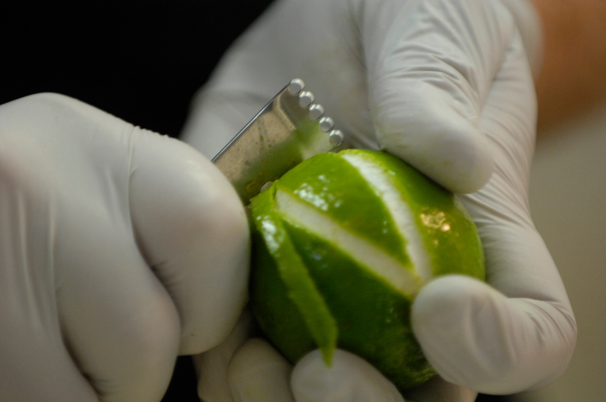 HICKAM AIR FORCE BASE, Hawaii -- Master Sgt. Craig Duclos, senior enlisted aide to Gen. Howie Chandler, Pacific Air Forces commander, and Department of Defense 2008 Enlisted Aide of the Year, carves lime peels for a mixed cocktail in preparation of a party at the general’s residence Dec. 12. Food preparation is just one of the many tasks that an enlisted aide performs on a daily basis; they also coordinate the care of the lawn, prepare the general luggage for trips, work closely with the catering staff of the officer's club, schedules appointments, and go grocery shopping. (U.S.  Air Force photo by Tech Sgt. Cohen A. Young)