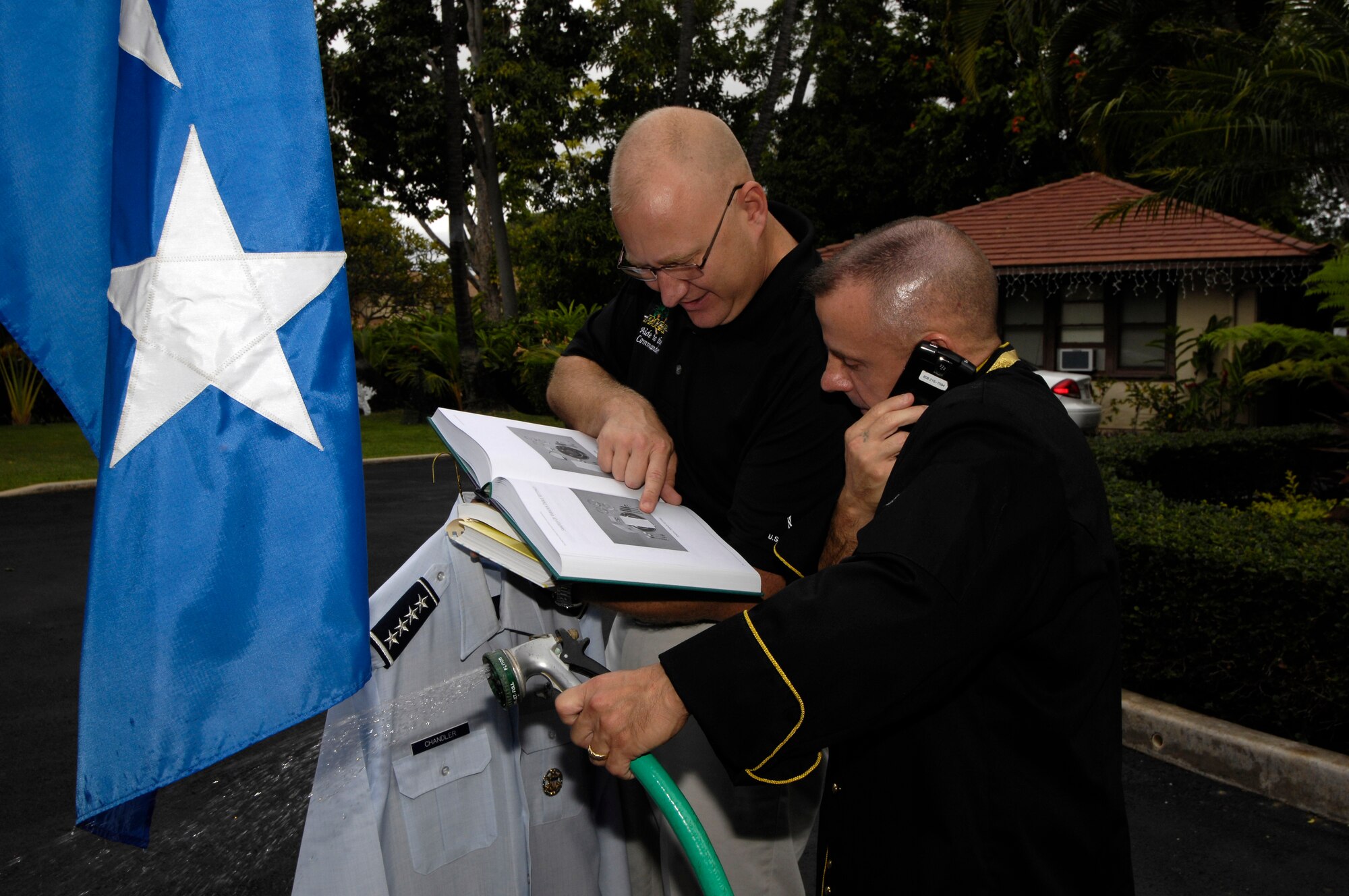 HICKAM AIR FORCE BASE, Hawaii -- Tech. Sgt. Damon J. Vitale, junior enlisted aide to Gen. Howie Chandler, commander of Pacific Air Forces, assists Master Sgt. Craig Duclos, senior enlisted aide to General Chandler, as he manages cooking, landscaping, dry cleaning and a busy blackberry Dec. 12. (U.S.  Air Force photo by Tech Sgt. Cohen A. Young) 