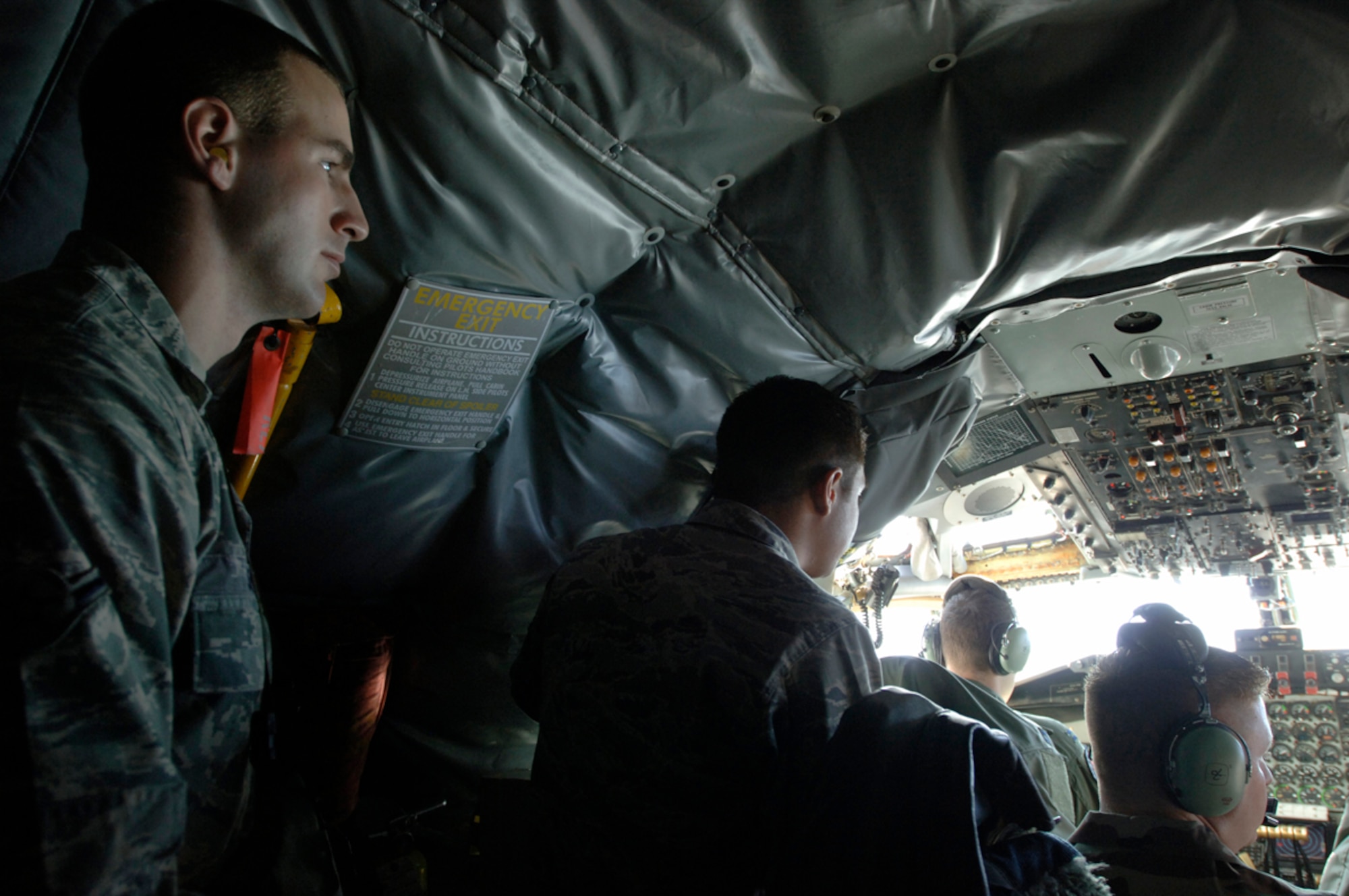 MCCONNELL AIR FORCE BASE, Kan. -- Airman Christopher Sibley, 22nd Aircraft
Maintenance Squadron, looks at the cockpit of a KC-135 Stratotanker during a 
refueling mission Dec. 11. Twenty three Airmen were aboard the flight to witness 
McConnell’s refueling mission and gain a better understanding of how their individual career fields enable that mission. (Photo by Senior Airman Laura Suttles)
