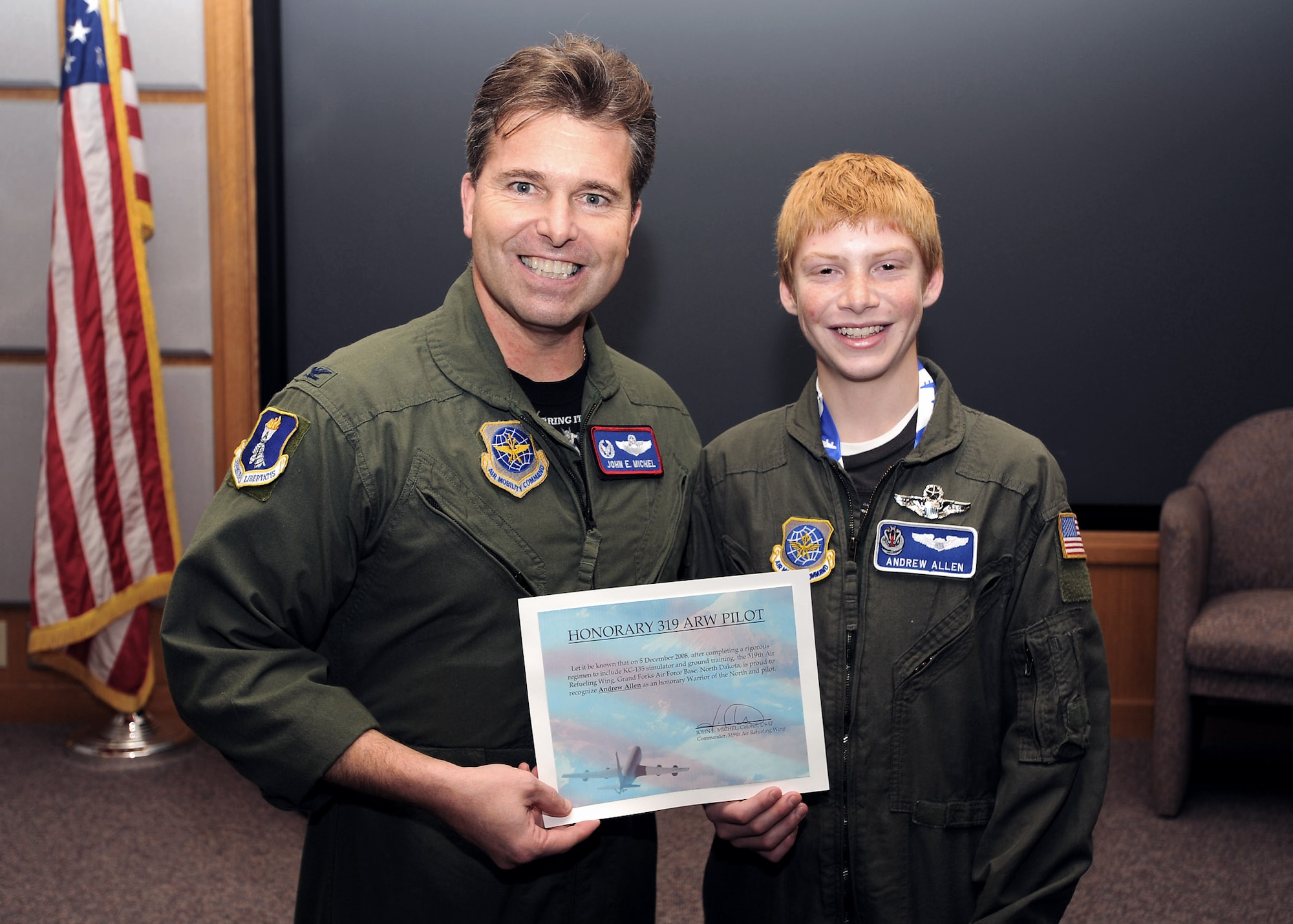 Col. John Michel presents Andrew Allen with a set of honorary pilot wings and a certificate at a presentation ceremony Dec. 5 at Grand Forks Air Force Base, N.D. Colonel Michel is the 319th Air Refueling Wing commander. (U.S. Air Force photo/Staff Sgt. Suellyn Nuckolls) 
