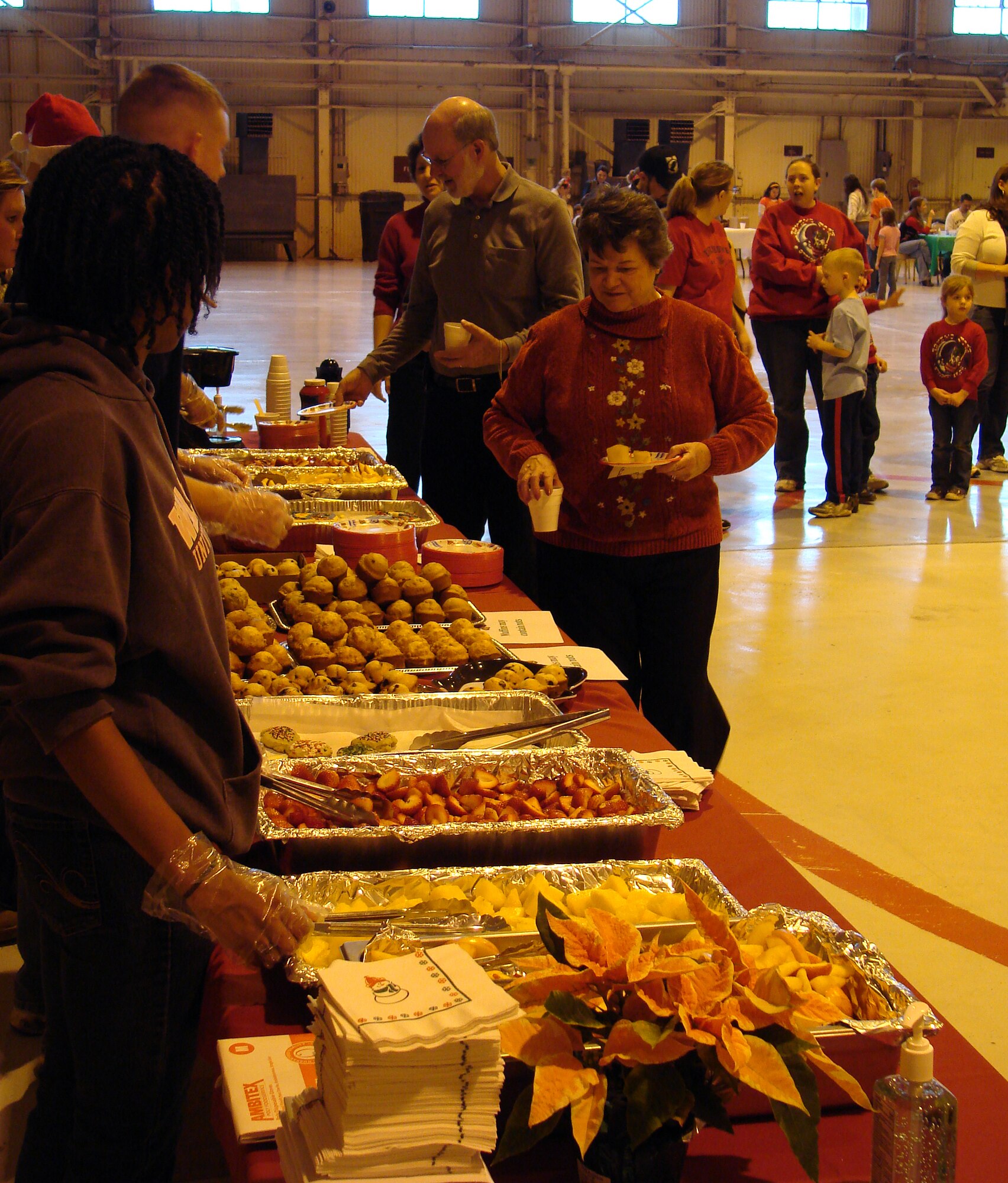 Families line up to enjoy the buffet at Breakfast with Santa on Dec. 13, in Hangar 170 on base. (U.S. Air Force photo by Joe B. Wiles)
