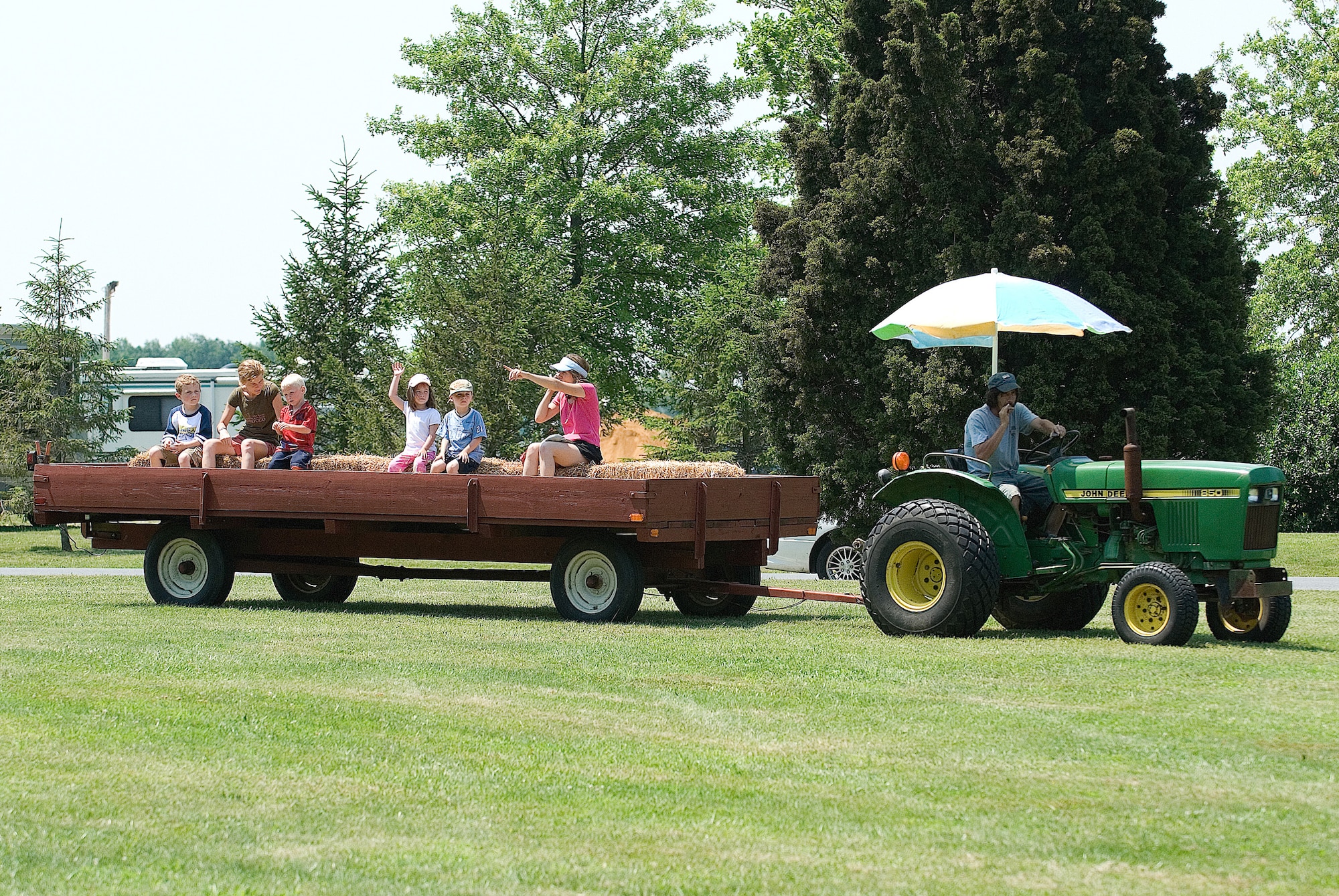 Team Dover family members enjoy a hay ride during the Wing Picnic June 13 at the Eagles Nest Picnic Area.  (U.S. Air Force Photo by Roland Balik)