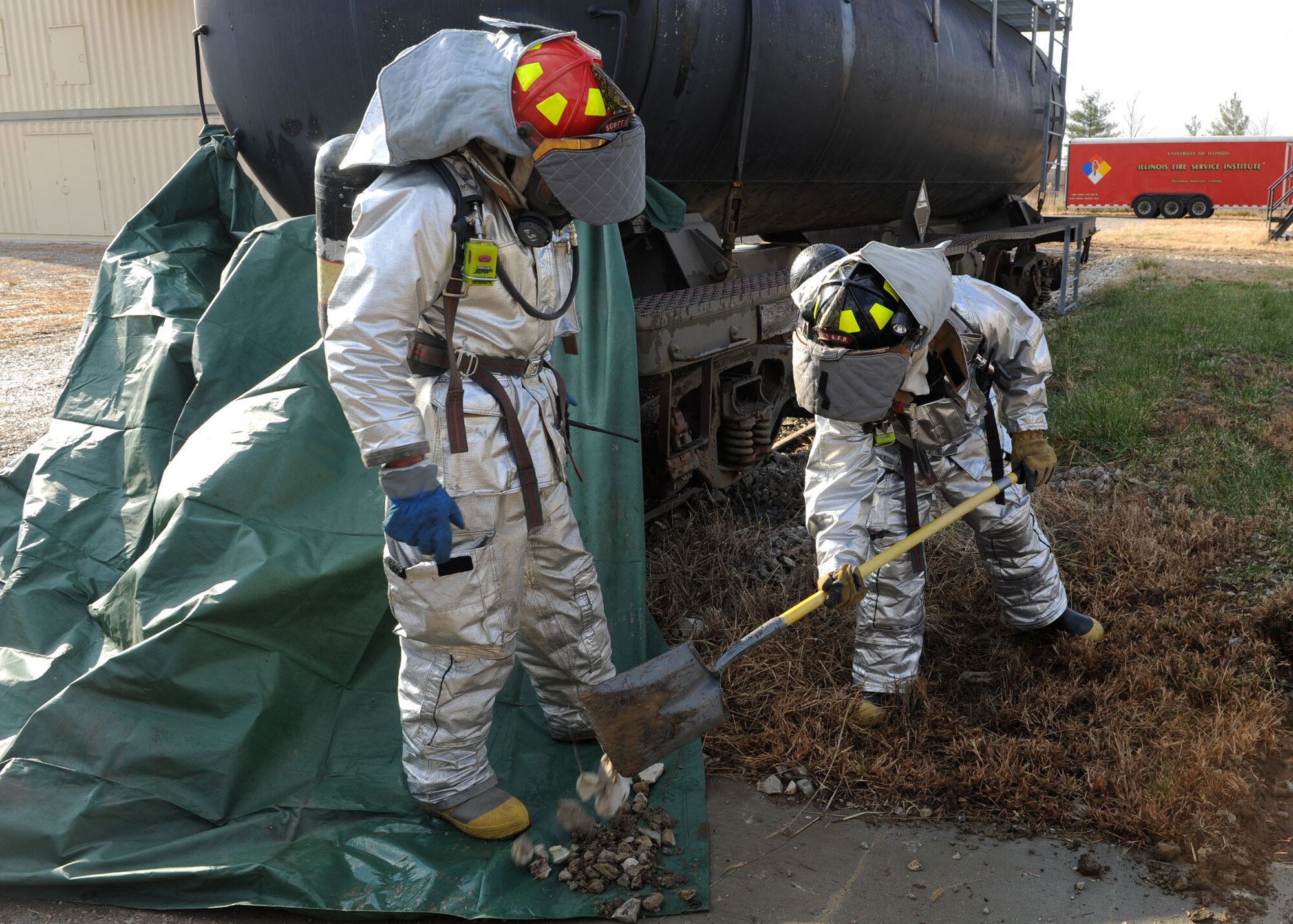 SCOTT AIR FORCE BASE, Ill. -- Two firefighters practice hazardous spill containment procedures on a train tank car during a base-wide exercise Friday. Tech. Sgt. Richard Buelow and Airman 1st Class Joshua Pavegilo are both from the 375th Civil Engineer Squadron fire emergency services flight. The base is preparing for an operation readiness inspection in the Spring of 2010. (U.S. Air Force photo/Airman 1st Class Wesley Farnsworth)