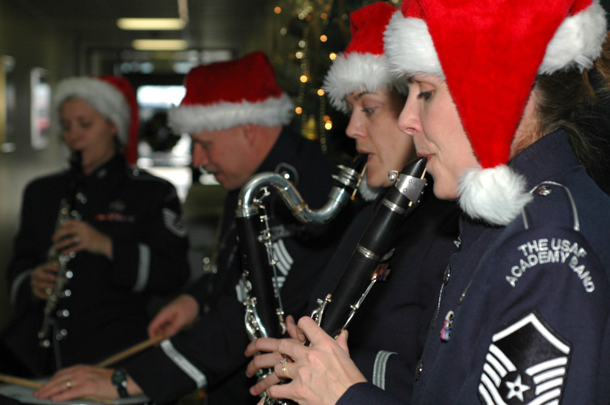 (Right to left): Master Sgts. Noelle Little and Claudia Weir, Chief Master Sgt. Scott Barbier and Tech. Sgt. Laura Bardill bring out the yule tide glee of 302nd Airlift Wing members Dec. 17, 2008, with a holiday music ensemble in the wing's headquarters building on Peterson Air Force Base in Colorado. Each members of the U.S. Air Force Academy band, they played throughout the base to sharpen their skills as well as provide additional morale and espirit de corps to its ranks. Sergeant Little plays the clarinet, Sergeant Weir makes use of the bass clarinet, Chief Barbier bangs on the percussion drum and Sergeant Bardill makes use of the clarinet. (U.S. Air Force photo/Stephen J. Collier)