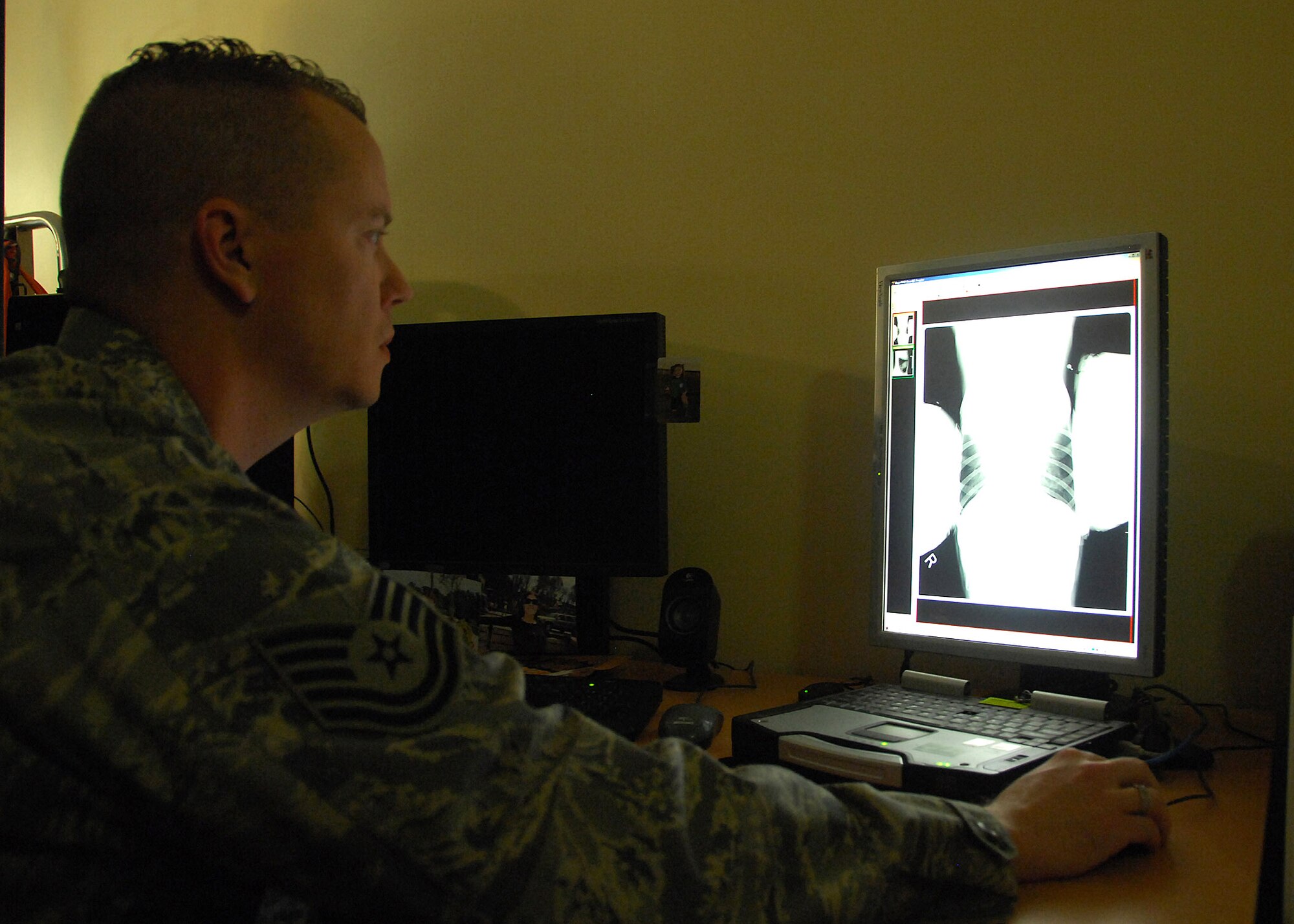 Tech. Sgt. Jeffrey Eller checks the X-ray of military working dog Zack Dec. 13 at an air base in Southwest Asia. Zack received an X-ray to see how his pneumonia had cleared since his last visit. Sergeant Eller is a 386th Expeditionary Medical Group X-ray technician deployed from Wright-Patterson Air Force Base, Ohio. He hails from Dallas. (U.S. Air Force photo/Tech. Sgt. Raheem Moore) 
