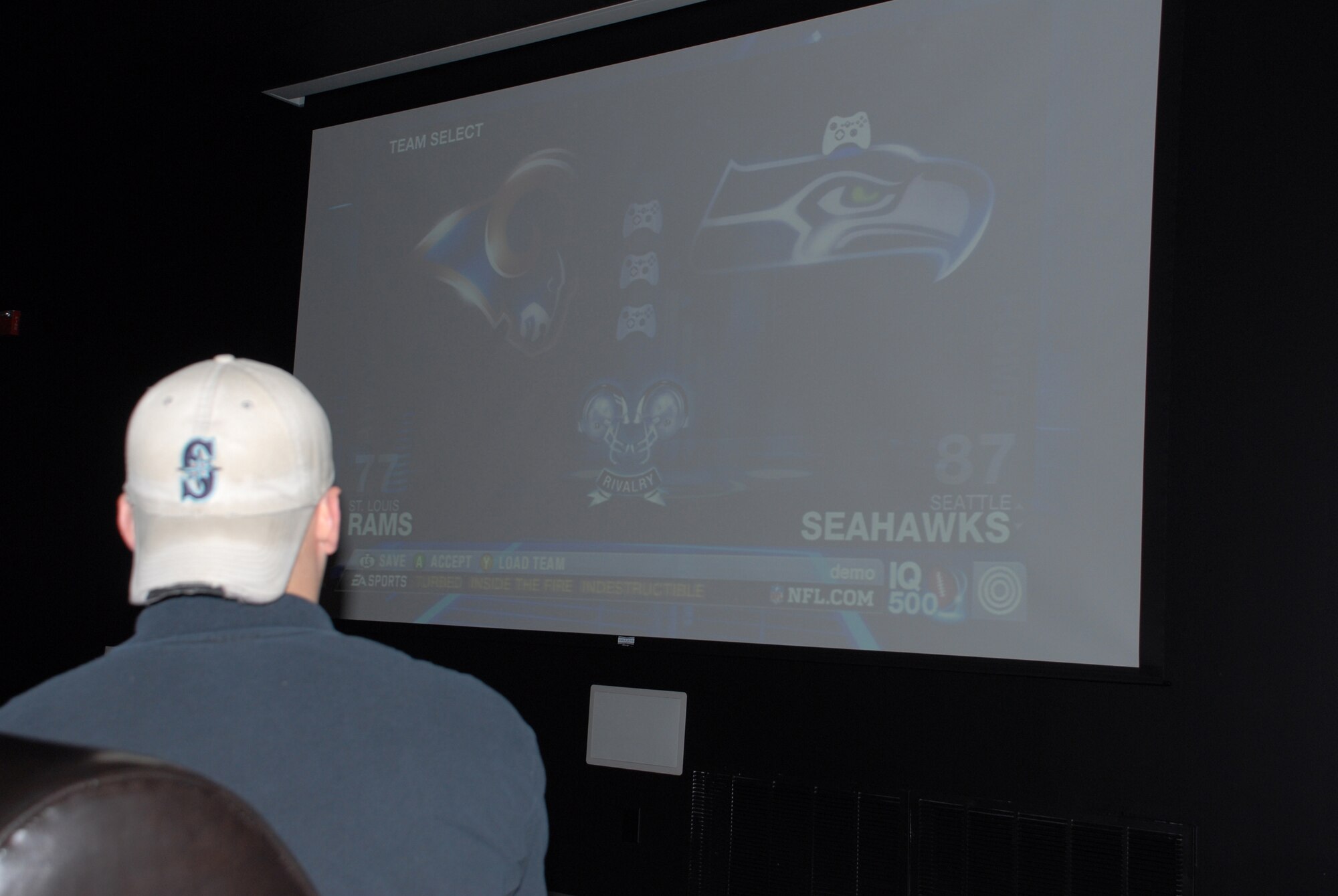 Logann Crawford, 436th Services Squadron recreational aide, tests out a vido game system on the Airman's Outpost 15-foot projection screen.  The Airman's Outpost has multiple video game systems available for use along with pool tables and an air hockey table.  They will also host a free Ultimate Fighting Championship event Dec. 27 from 8 p.m. - 1:30 a.m.  The event is open to DoD ID card holders 18 years old and up.