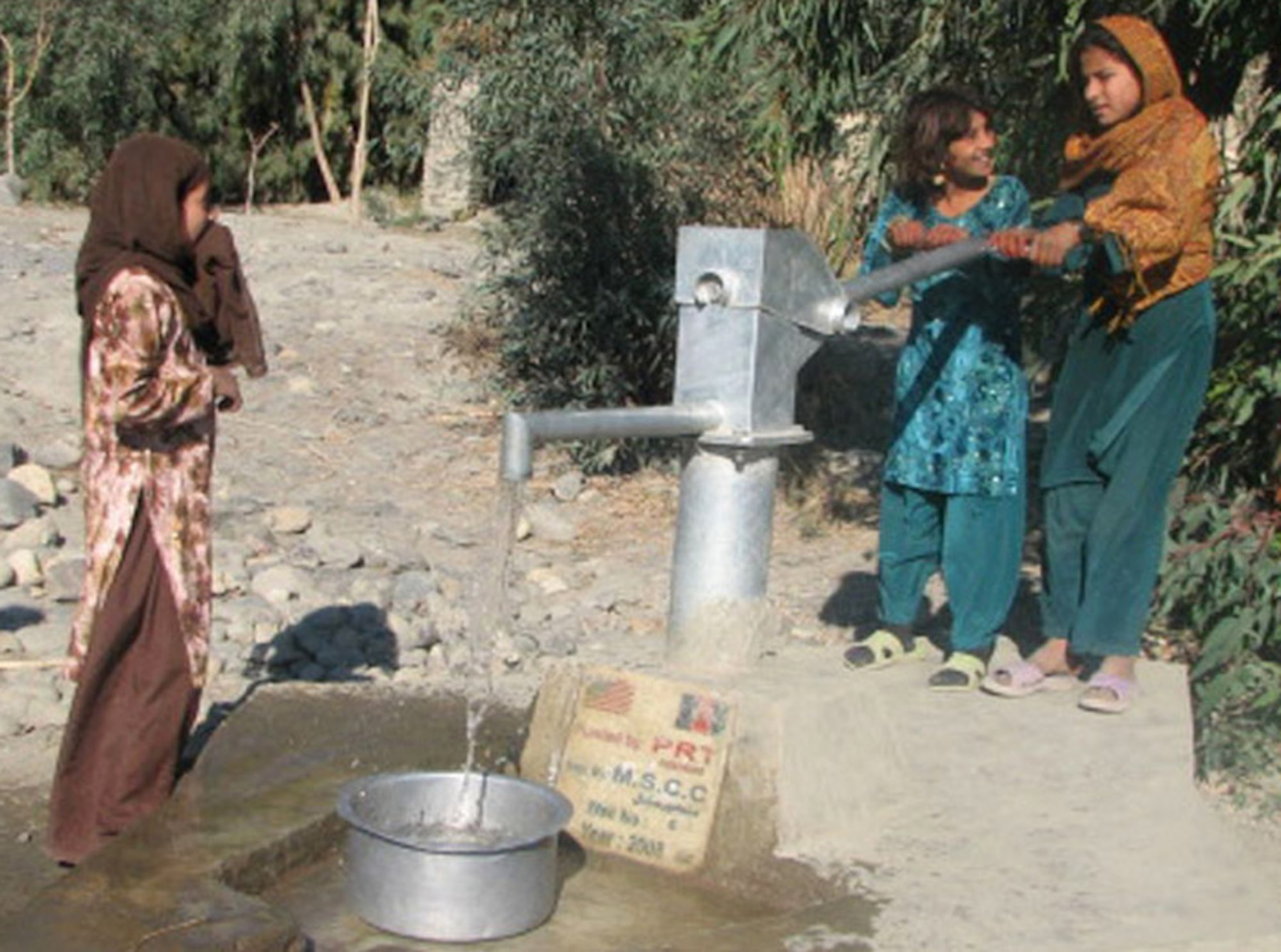 Afghan girls draw water from a recently completed village well in the Kuz Konar district of Afghanistan's Nangarhar Province. The Nangarhar Provincial Reconstruction Team completed an eight-well project that will bring a vital water source to thousands of people in six districts. (U.S. Army photo) 
